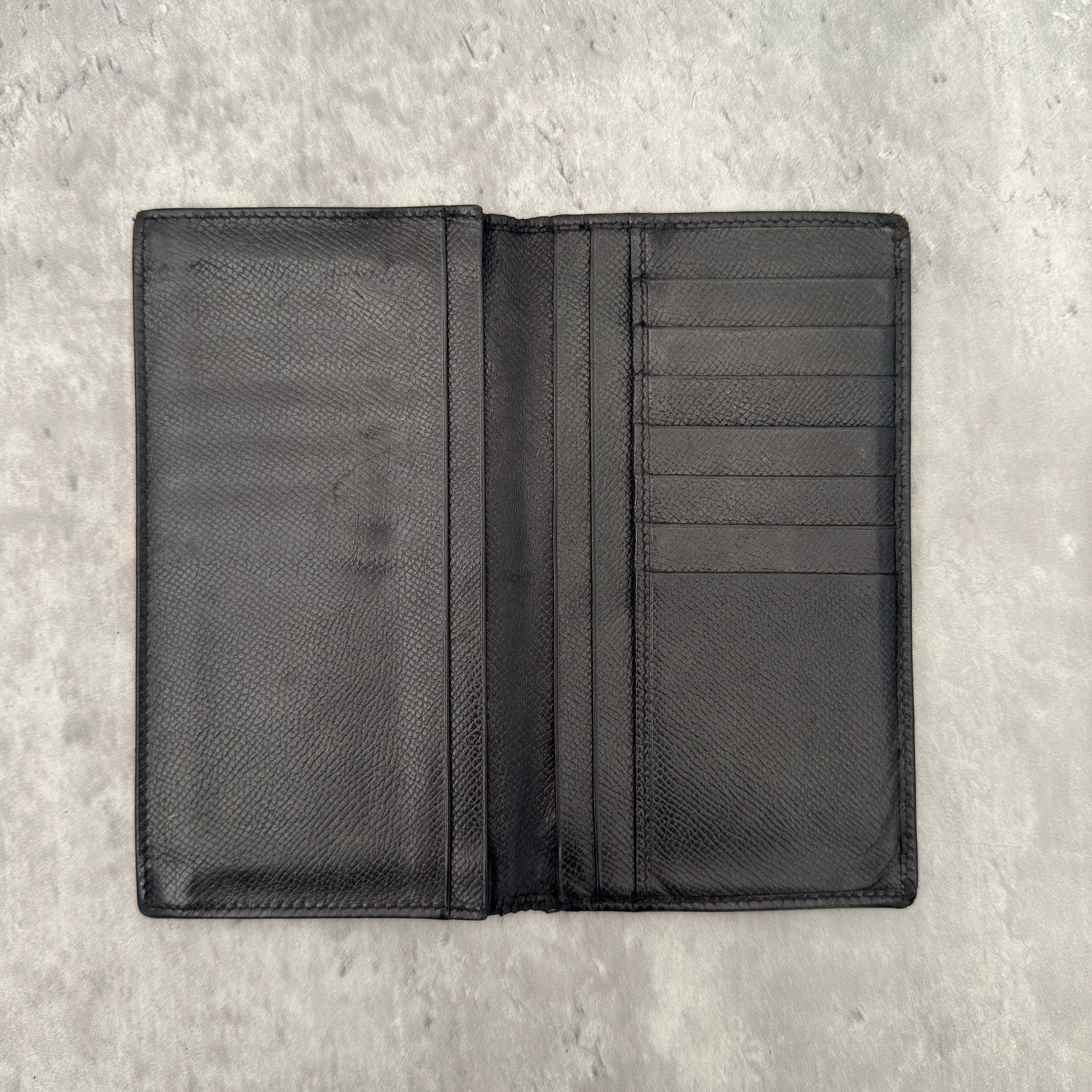 Bvlgari Bi-Fold Leather Black Long Wallet, crafted from textured black leather with multiple card slots and bill compartments for organization.