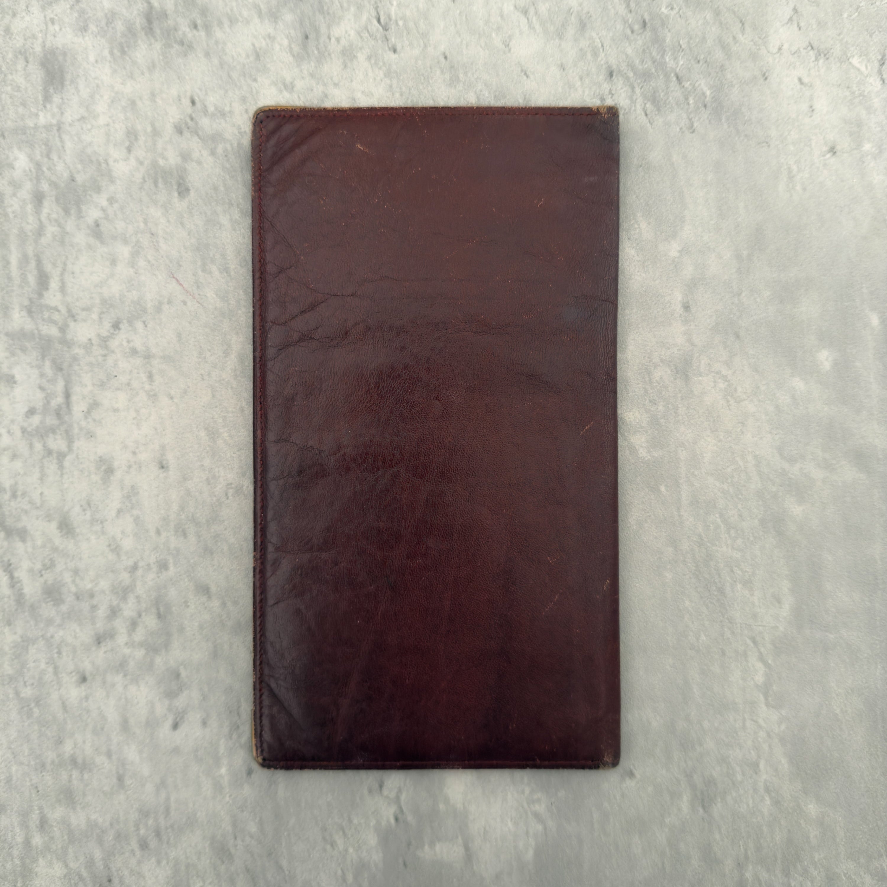 Cartier Must De Cartier Long Wallet in burgundy leather with embossed logo, gold-tone corner accents, and multiple compartments for organised storage.