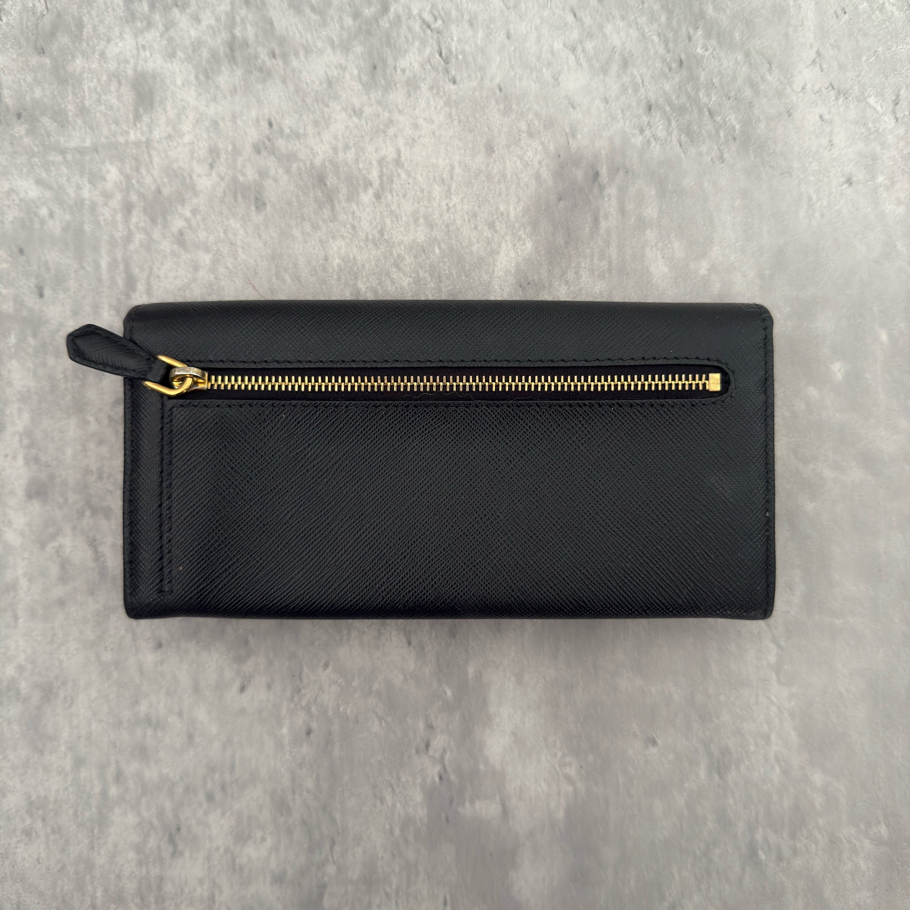 Prada Milano Black Saffiano Leather Ribbon Bow Long Wallet, crafted from textured black Saffiano leather with a gold-tone logo plaque and ribbon bow detail.