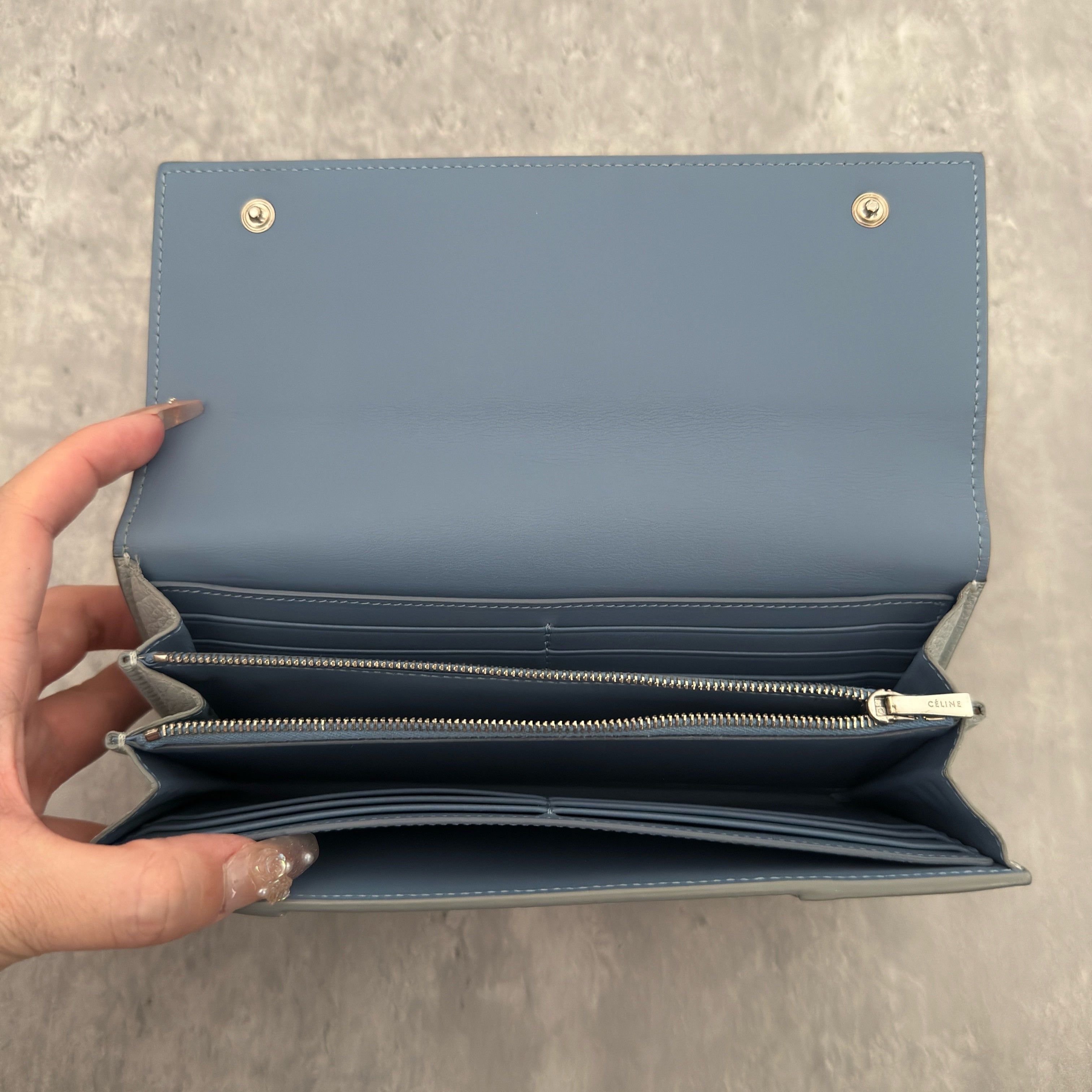 Celine Long Bifold Baby Blue Long Wallet, crafted from grained leather with a clipped button snap closure and spacious interior.