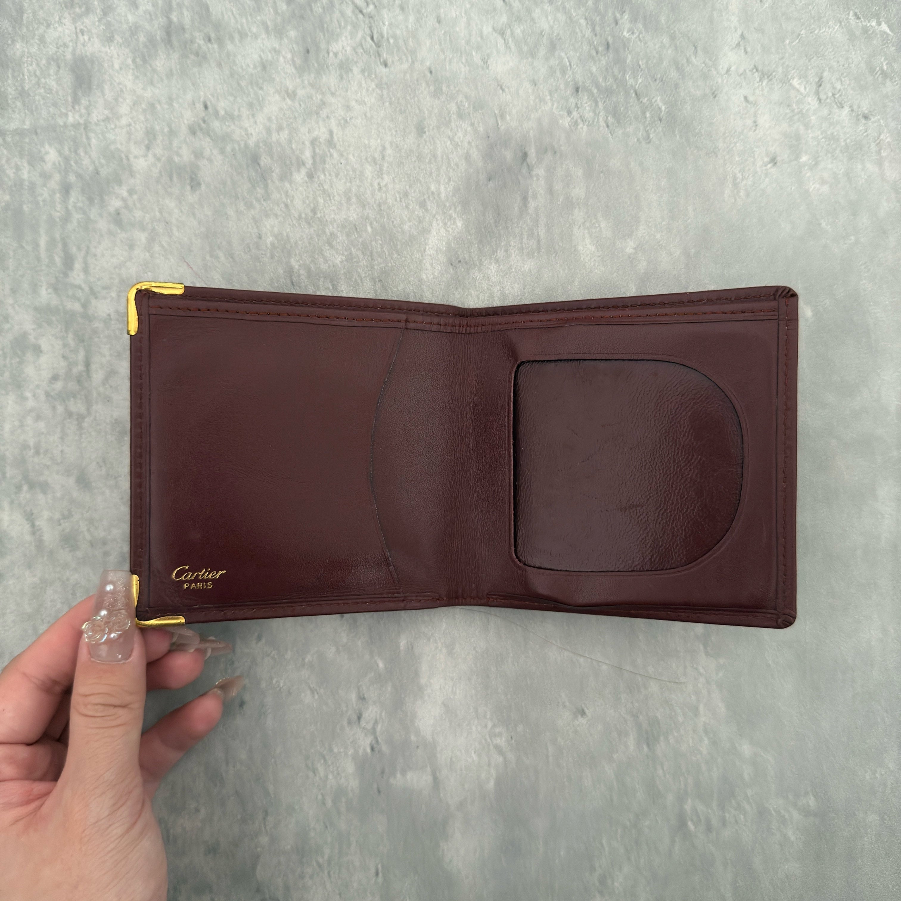 Cartier Mast Line Bordeaux Burgundy Wallet in premium leather, featuring gold-tone corner accents and embossed logo.
