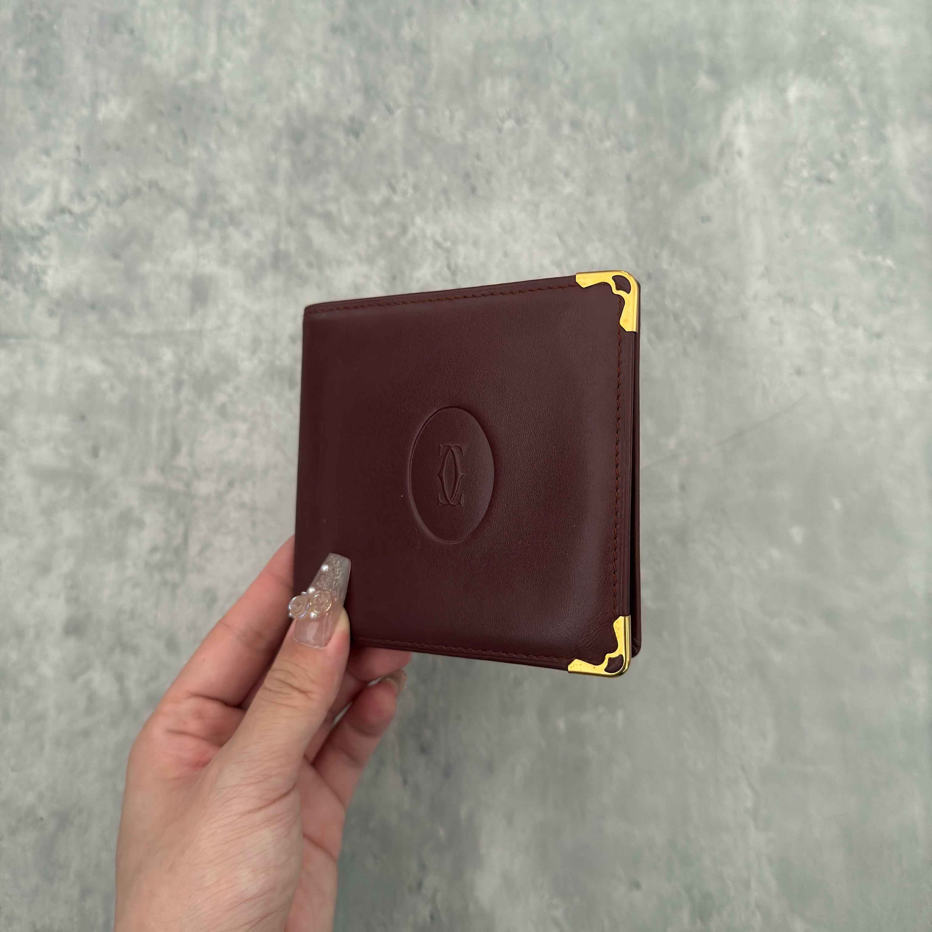 Cartier Mast Line Bordeaux Burgundy Wallet in premium leather, featuring gold-tone corner accents and embossed logo.