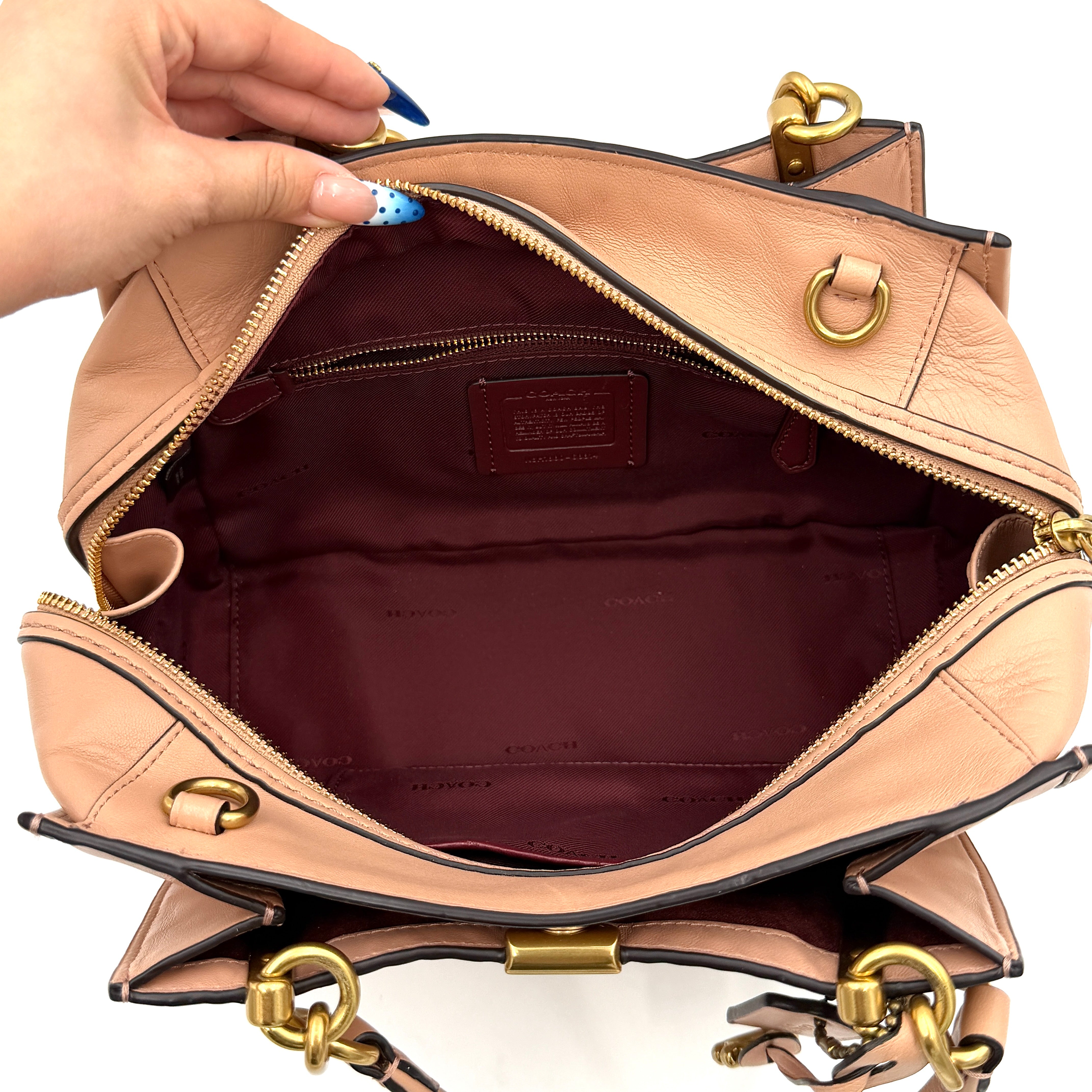 Coach Dreamer 27 handbag in nude pink leather with Deco quilting, gold rivets, and detachable strap, displayed elegantly on a plain background.