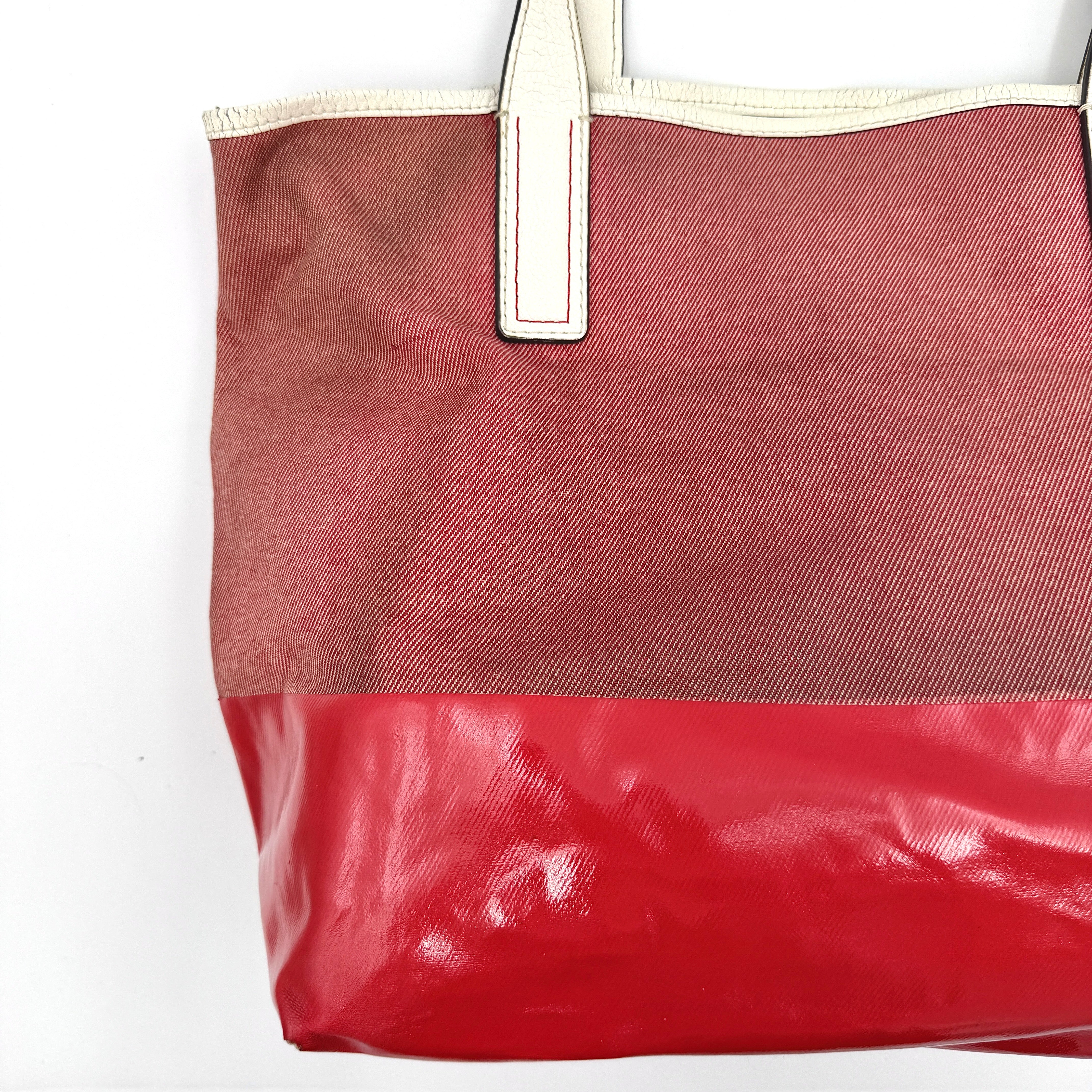 Kate Spade Ash Street Logo Tote in red canvas with glossy red leather base and ivory handles, shown against a white background.