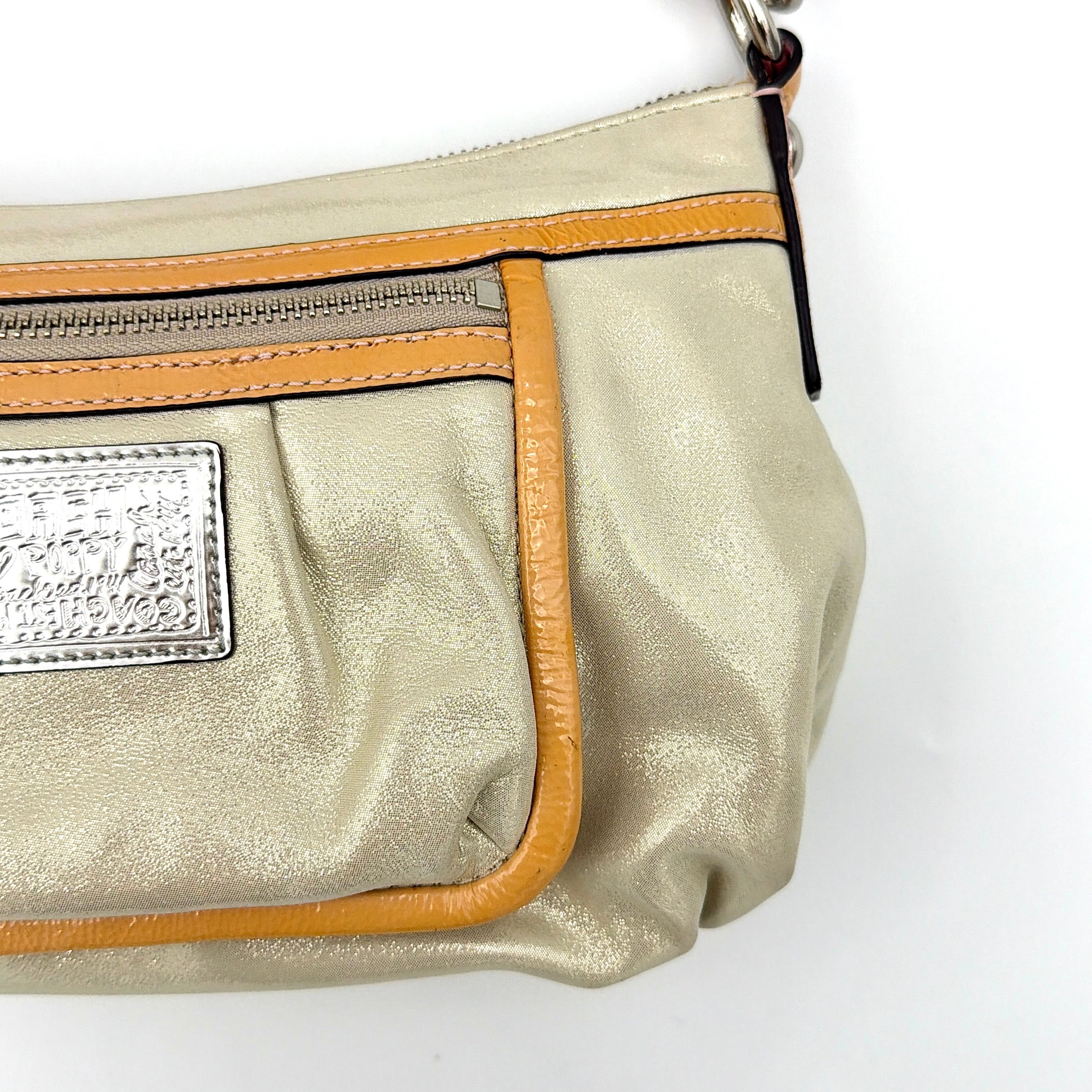 Coach Poppy Sparkle Groovy bag in cream with tan trim, metallic plaque, and detachable shoulder strap displayed alongside.