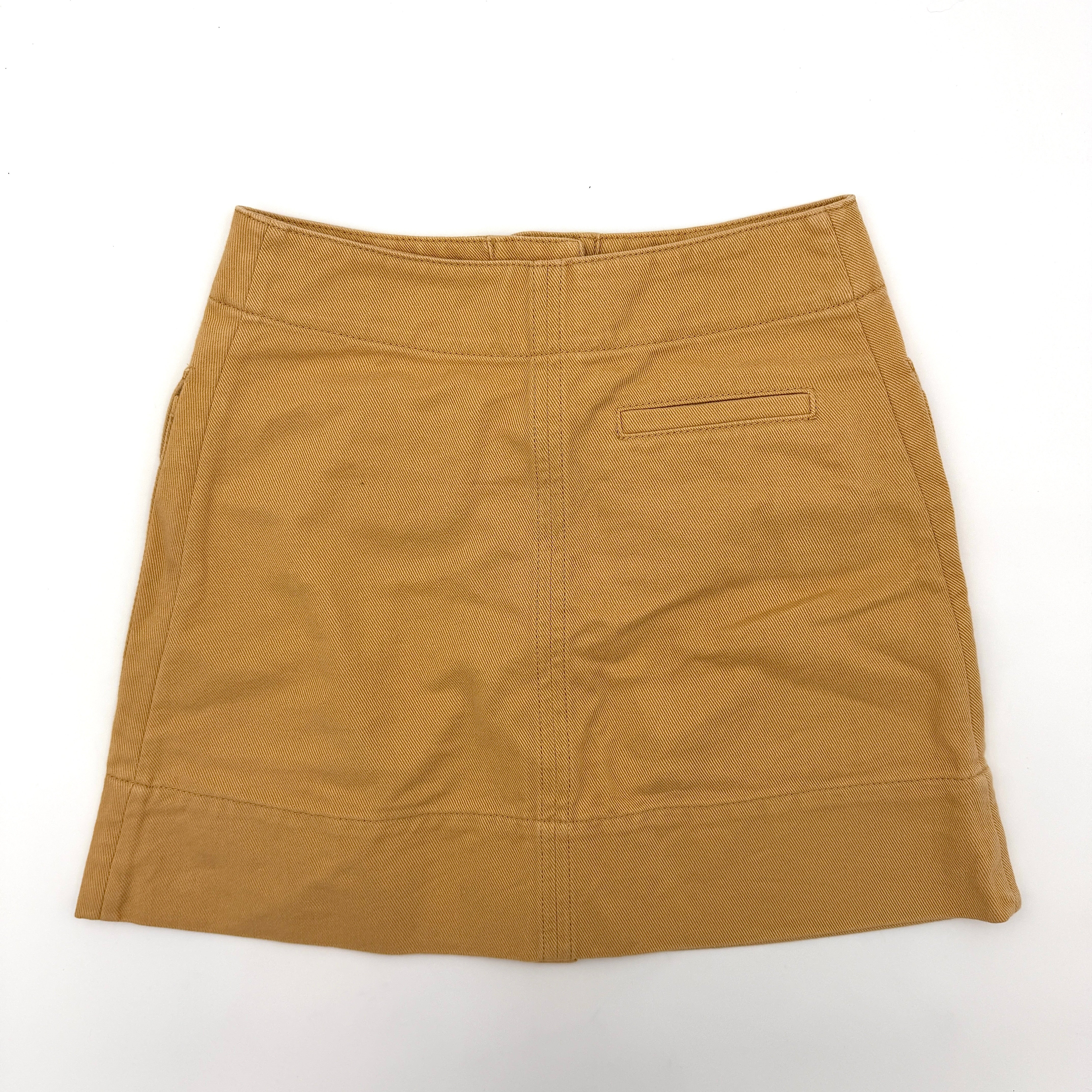 Acne Studios cream and tan cotton drill mini skirt with oversized flap pockets and front button closure, styled flat.