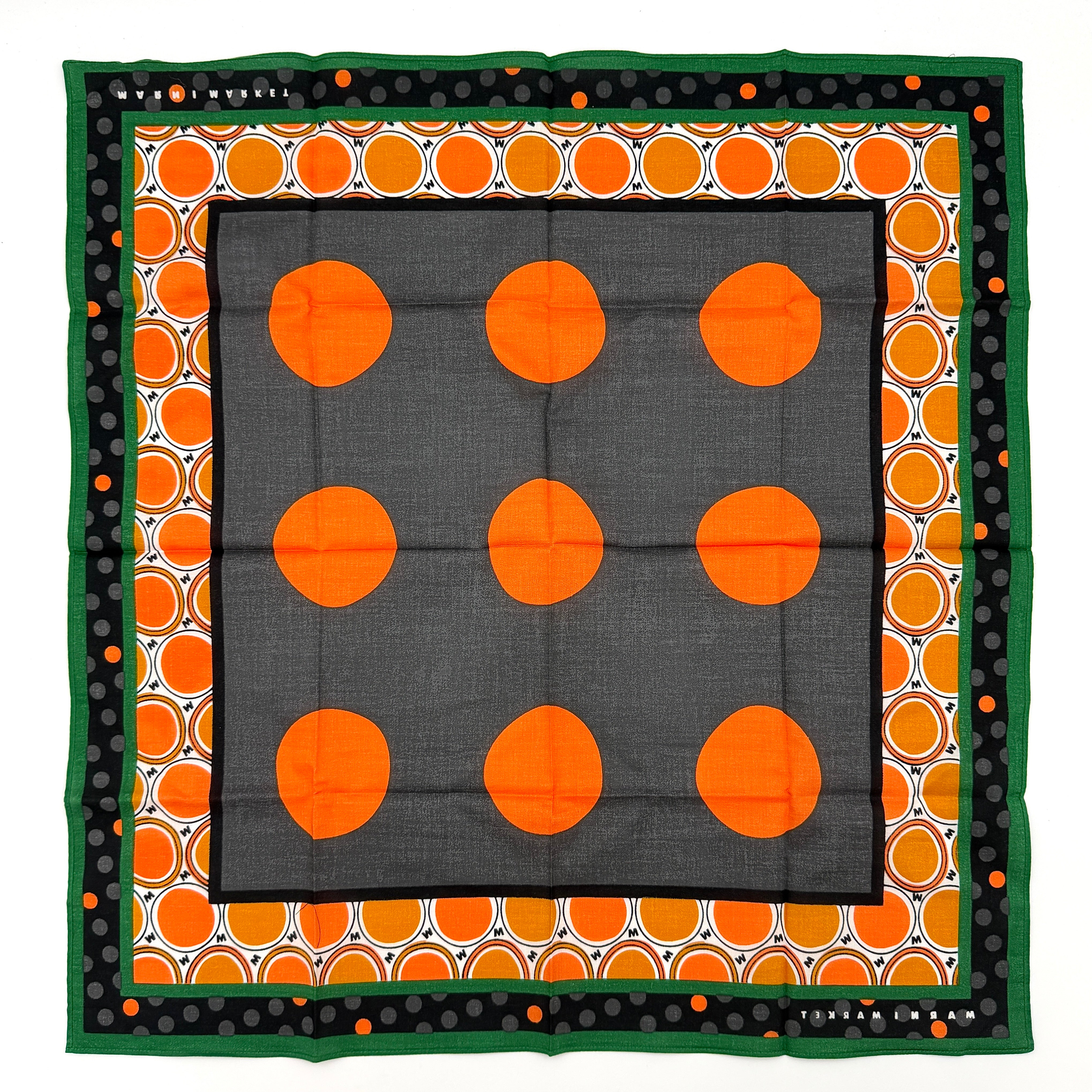 A Marni Market square scarf in orange polka dots and geometric borders with green edges, neatly laid out to show its graphic pattern.