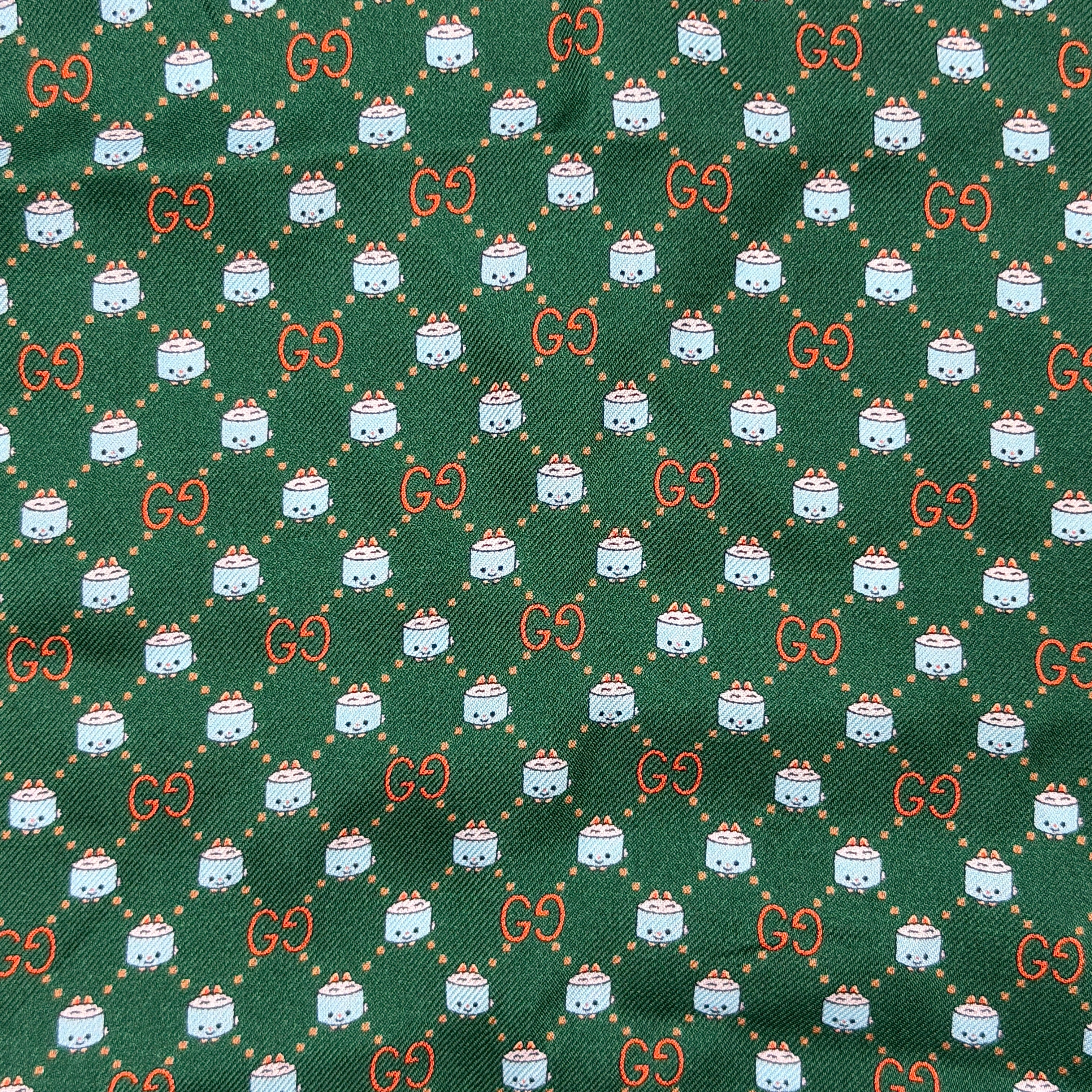 Gucci GG Monogram Silk Scarf in green silk, featuring a playful allover GG pattern and orange rolled edge.