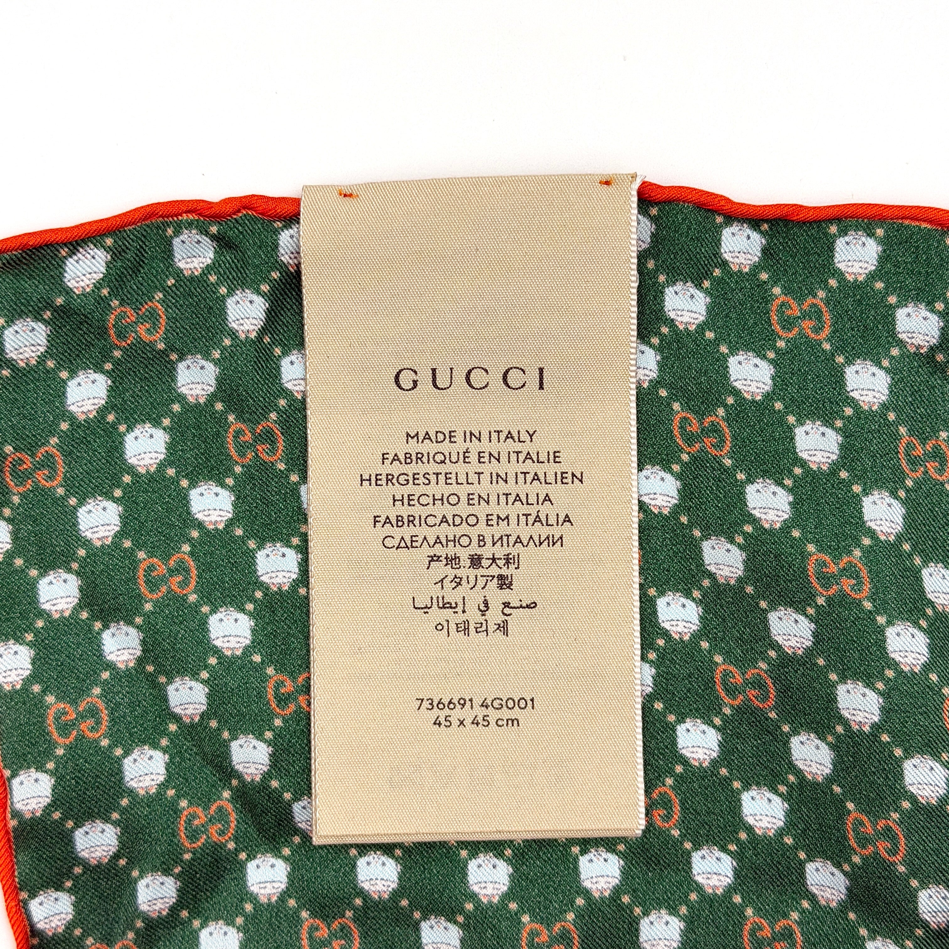 Gucci GG Monogram Silk Scarf in green silk, featuring a playful allover GG pattern and orange rolled edge.