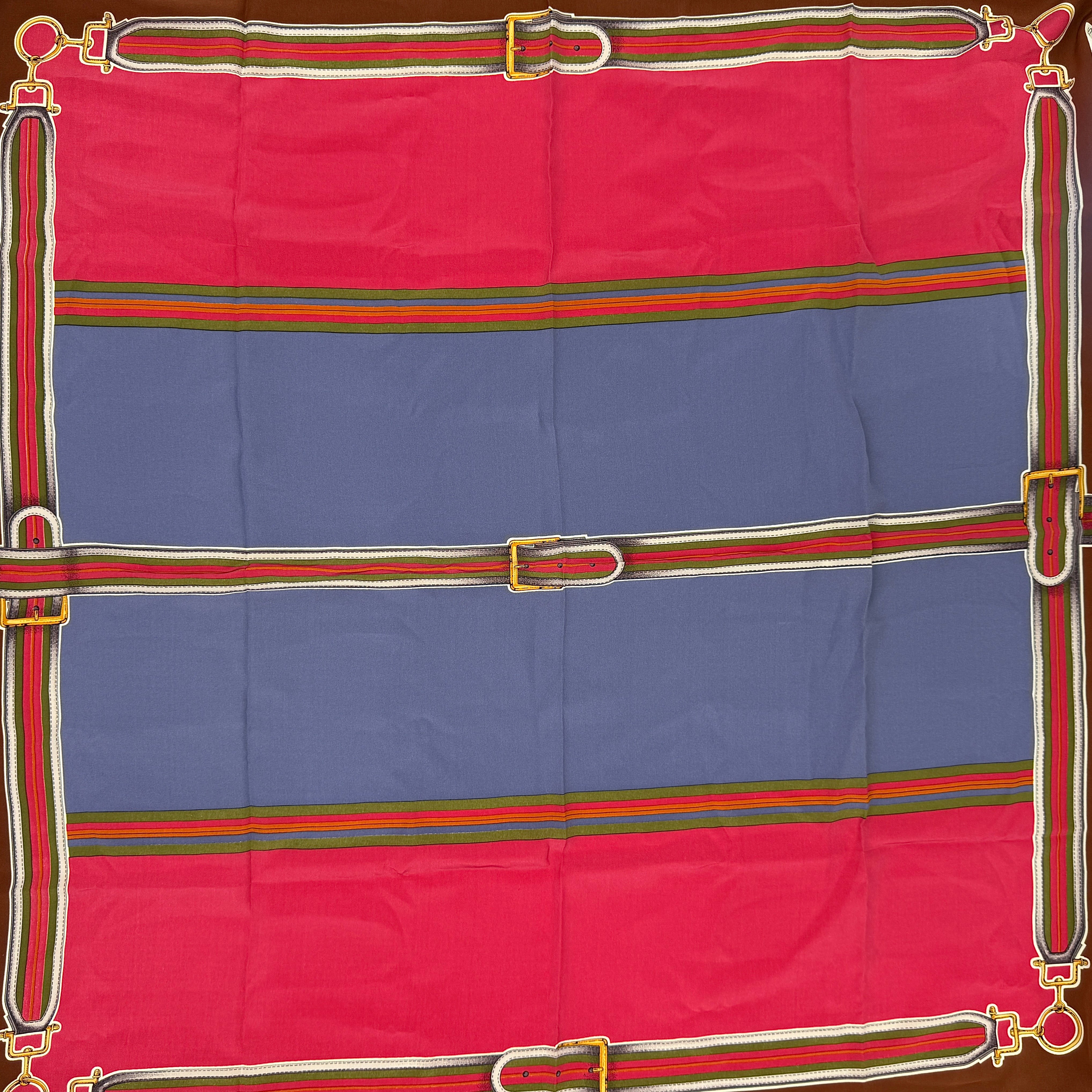 Celine silk scarf in raspberry pink, periwinkle blue, and brown with illustrated buckle and strap motifs.