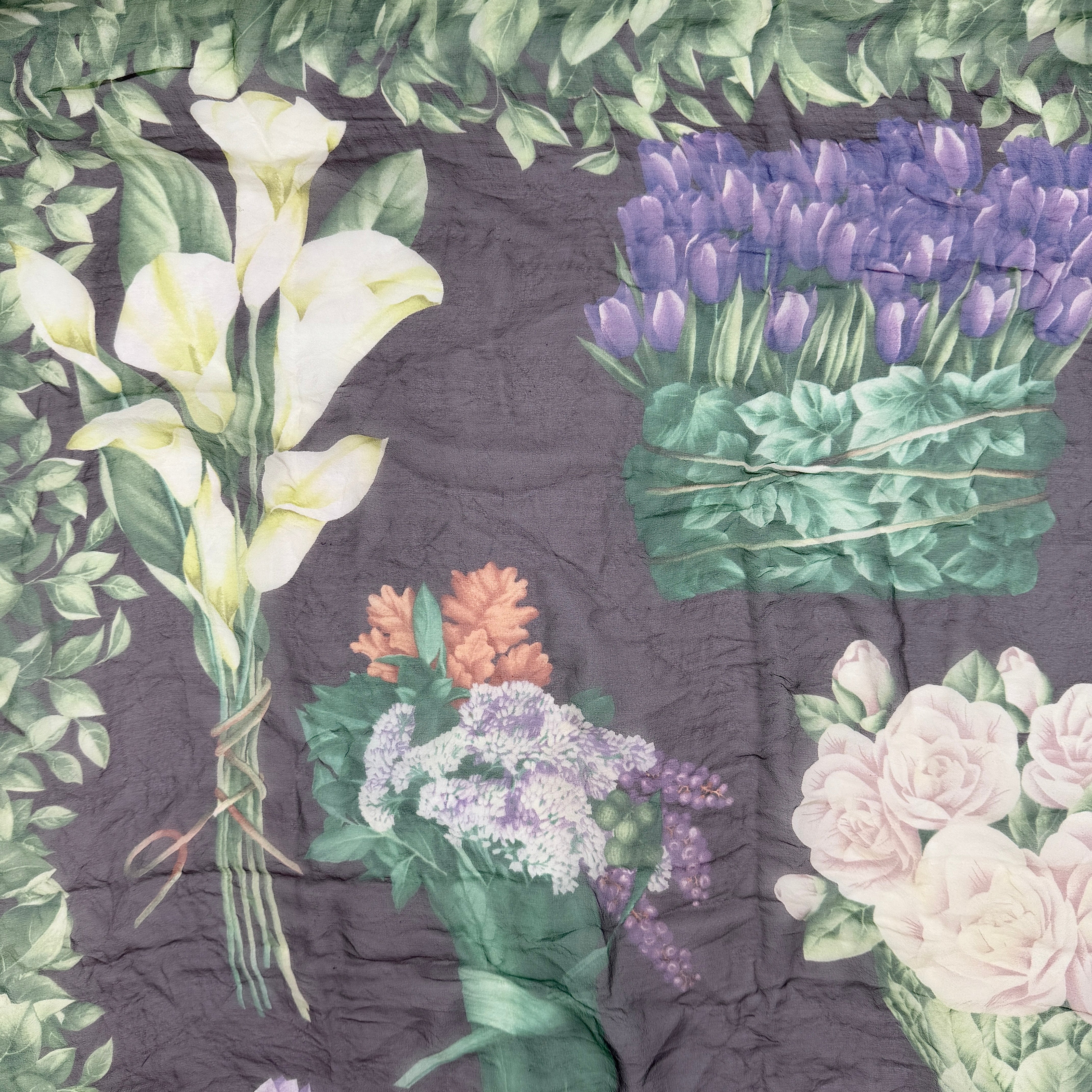 Gucci silk scarf adorned with artistic multicolour floral bouquets and leafy green border, elegantly draped to showcase its lightweight, sheer texture.