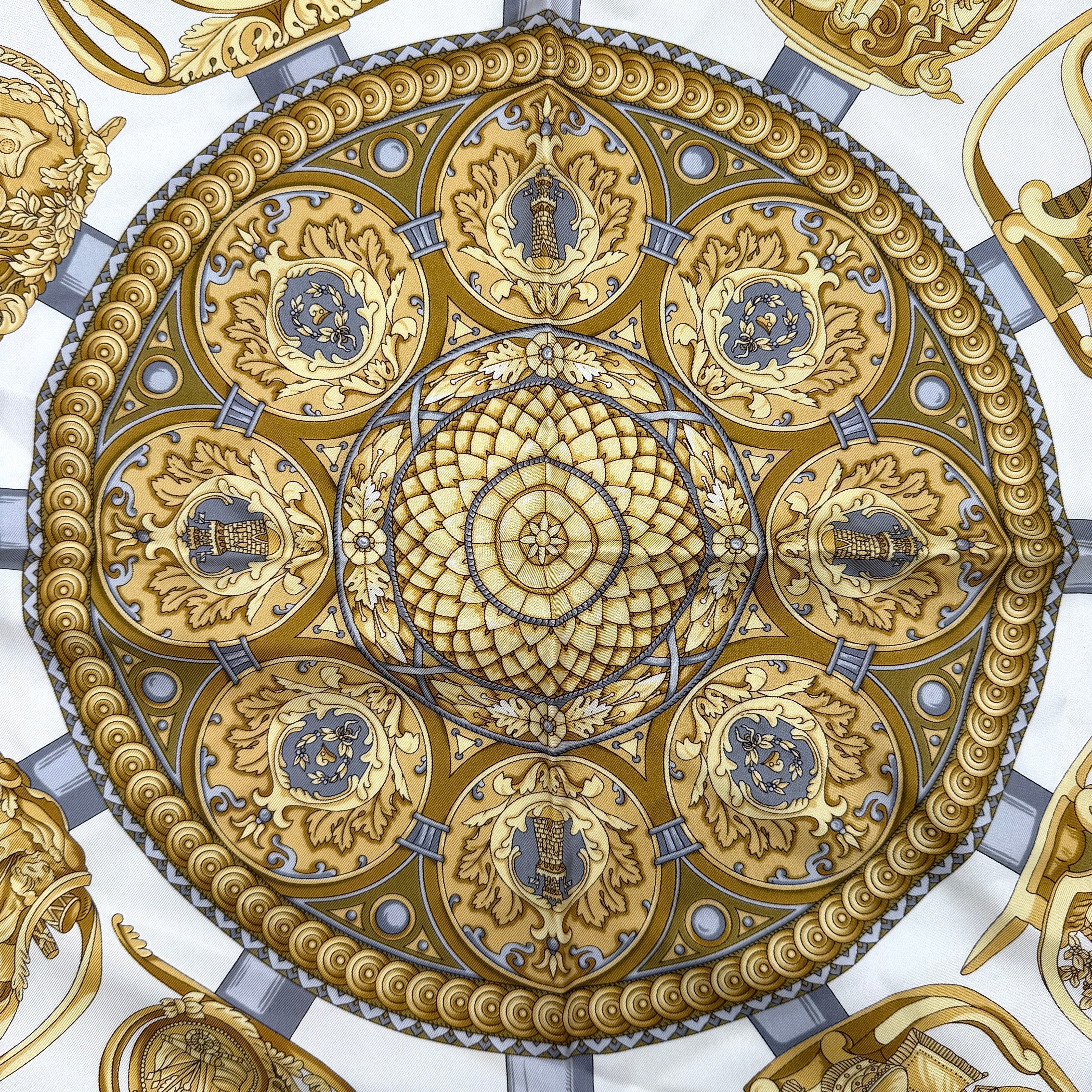 Gucci silk scarf in gold and white, featuring an intricate equestrian medallion design with ornate sabres and classical borders.