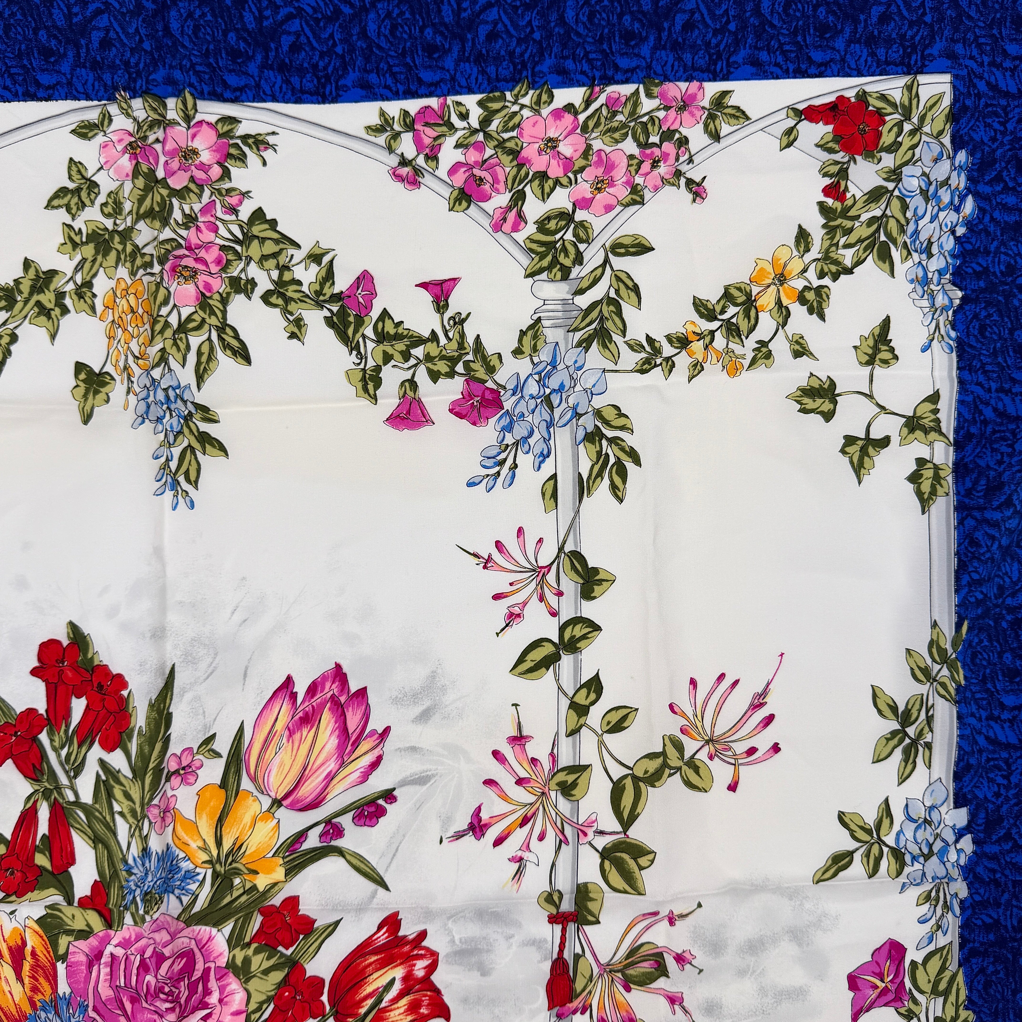 Dior silk scarf featuring an ornate multicolour floral print with a deep blue border.