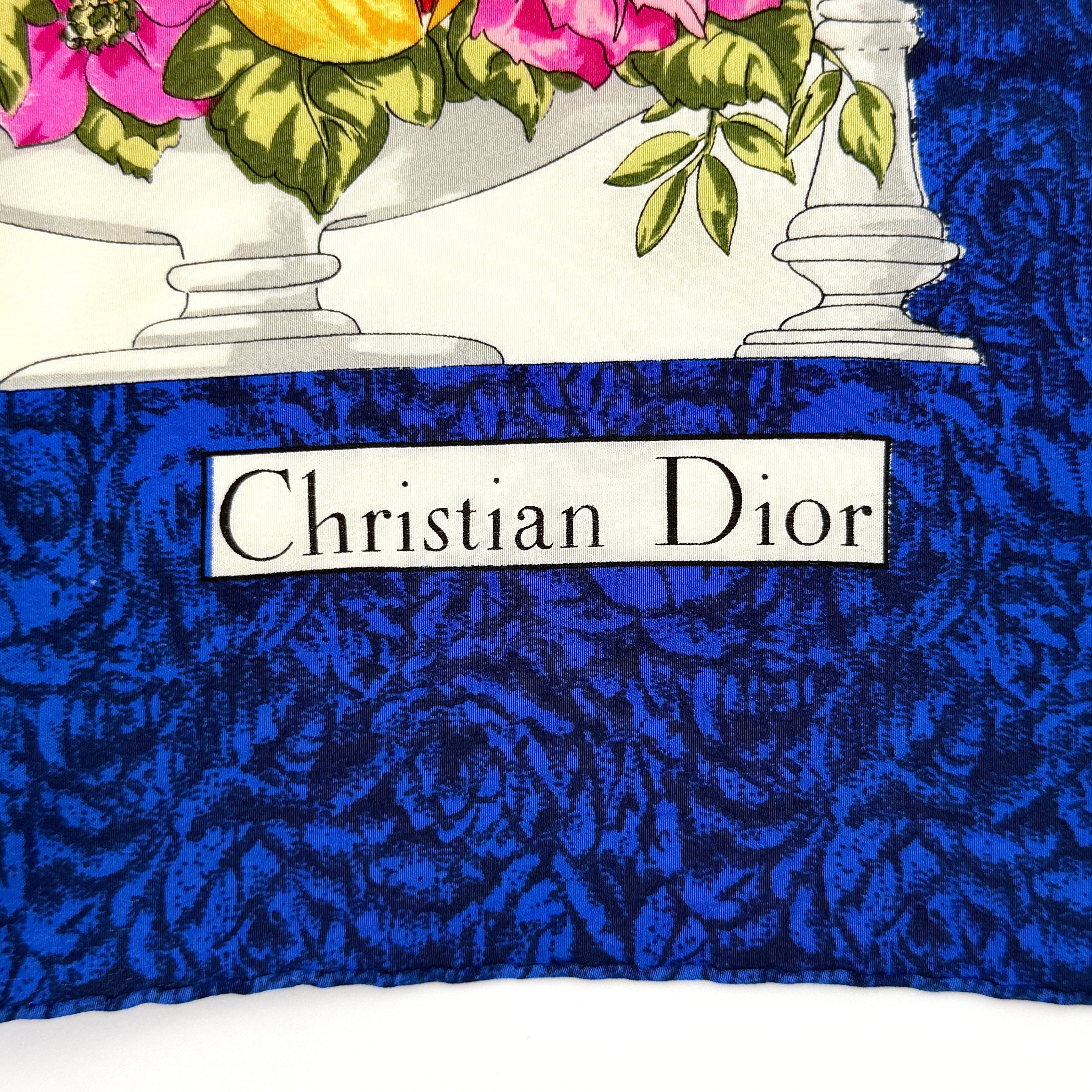 Dior silk scarf featuring an ornate multicolour floral print with a deep blue border.