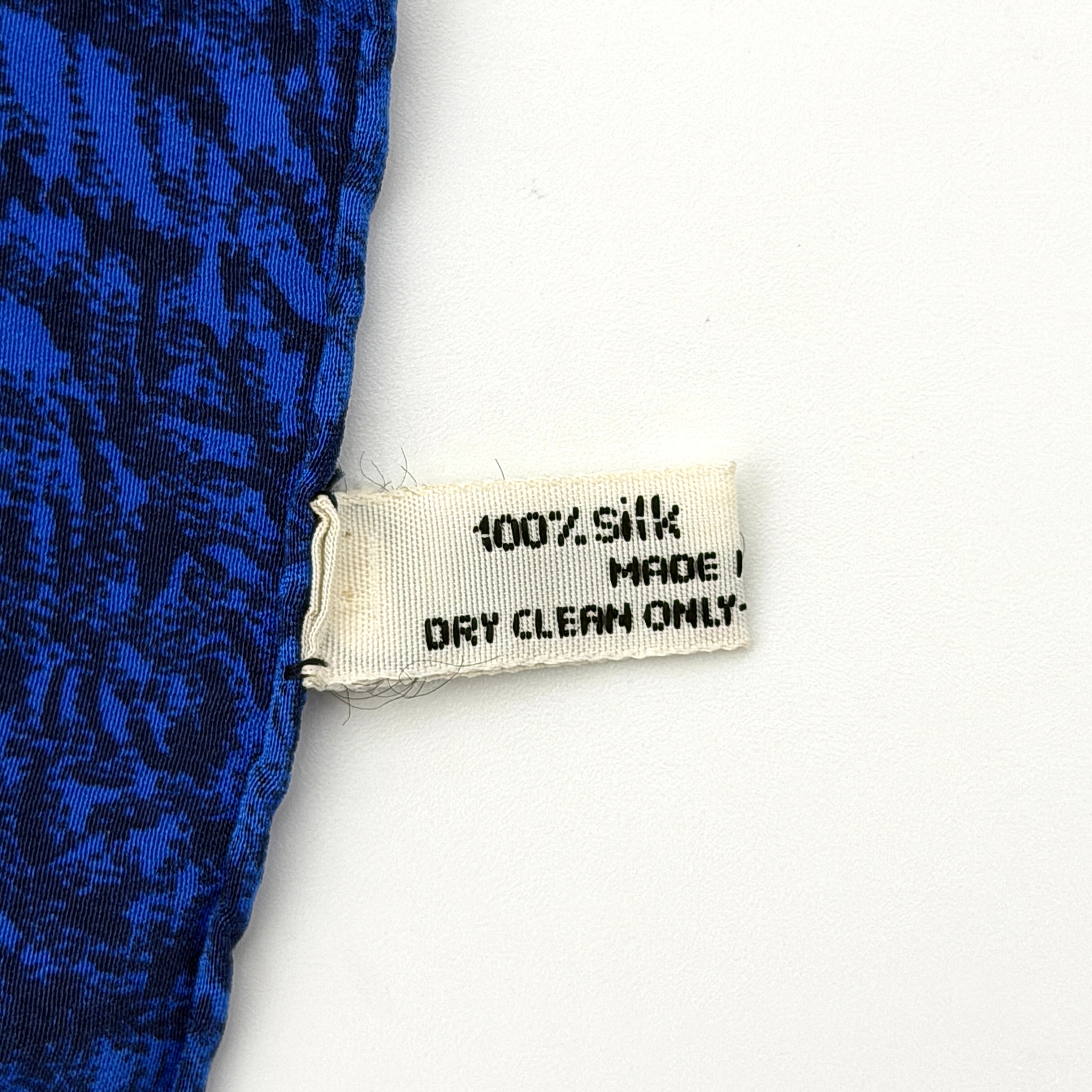 Dior silk scarf featuring an ornate multicolour floral print with a deep blue border.