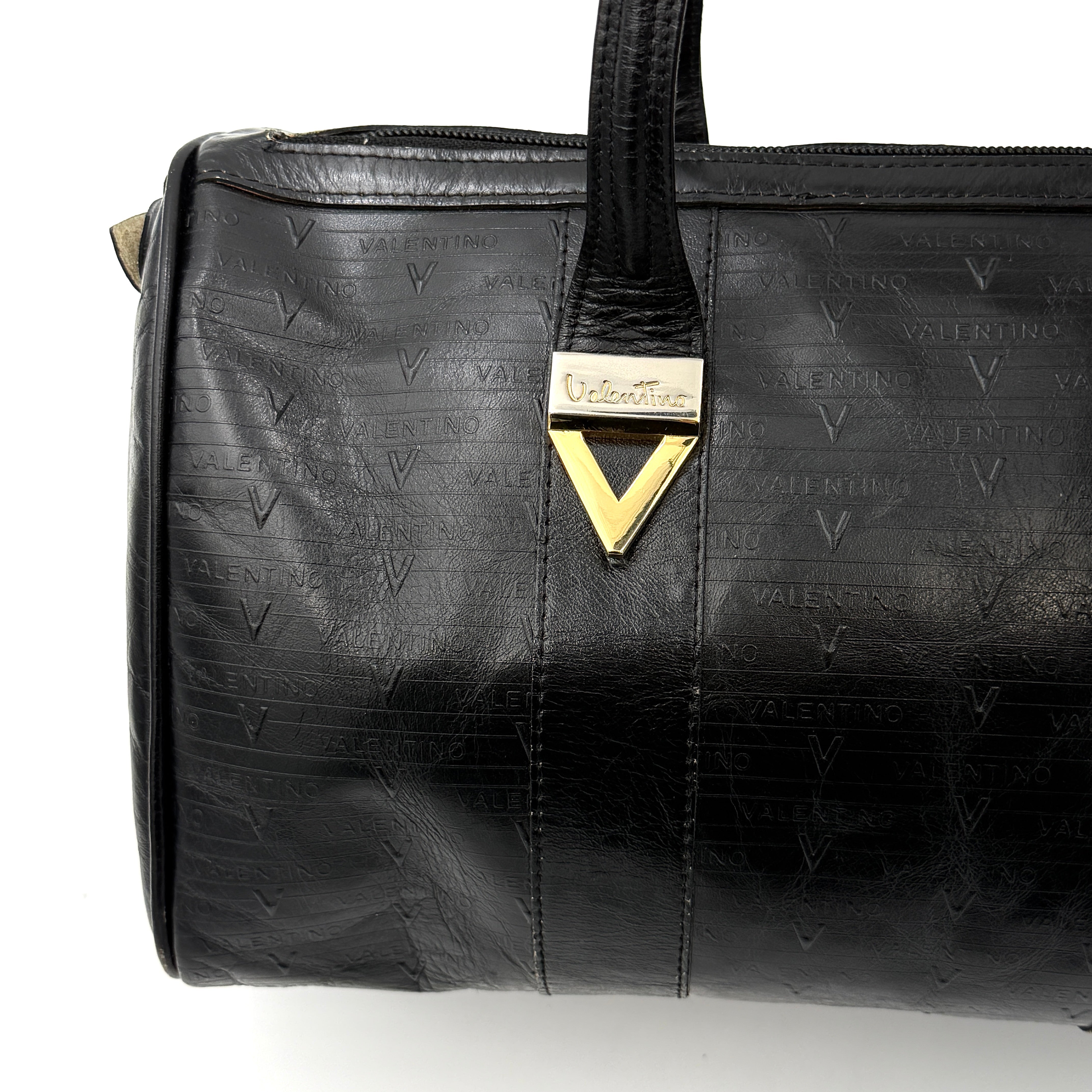 Valentino Monogram Boston Bag in black embossed leather with gold-tone V hardware and dual top handles.