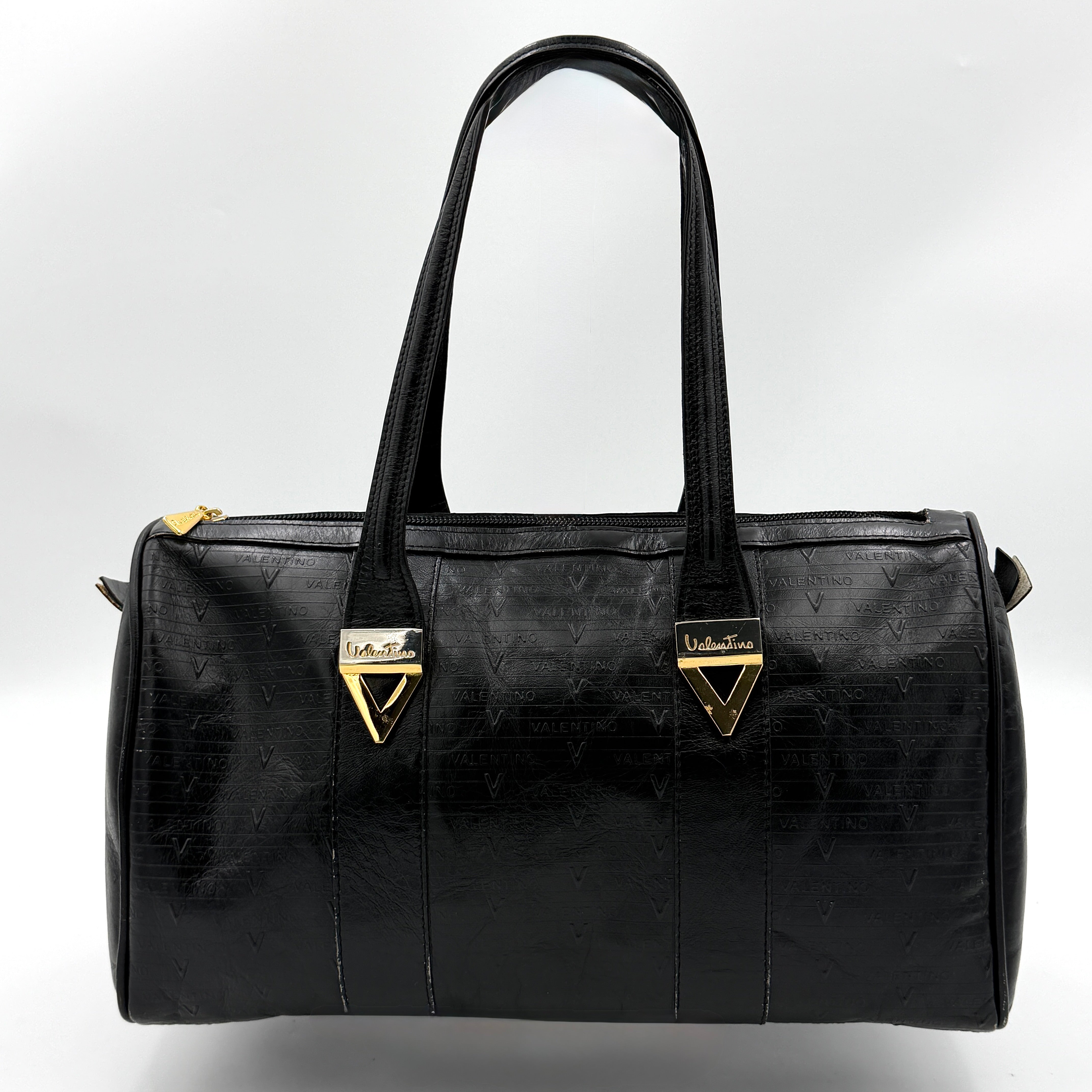 Valentino Monogram Boston Bag in black embossed leather with gold-tone V hardware and dual top handles.