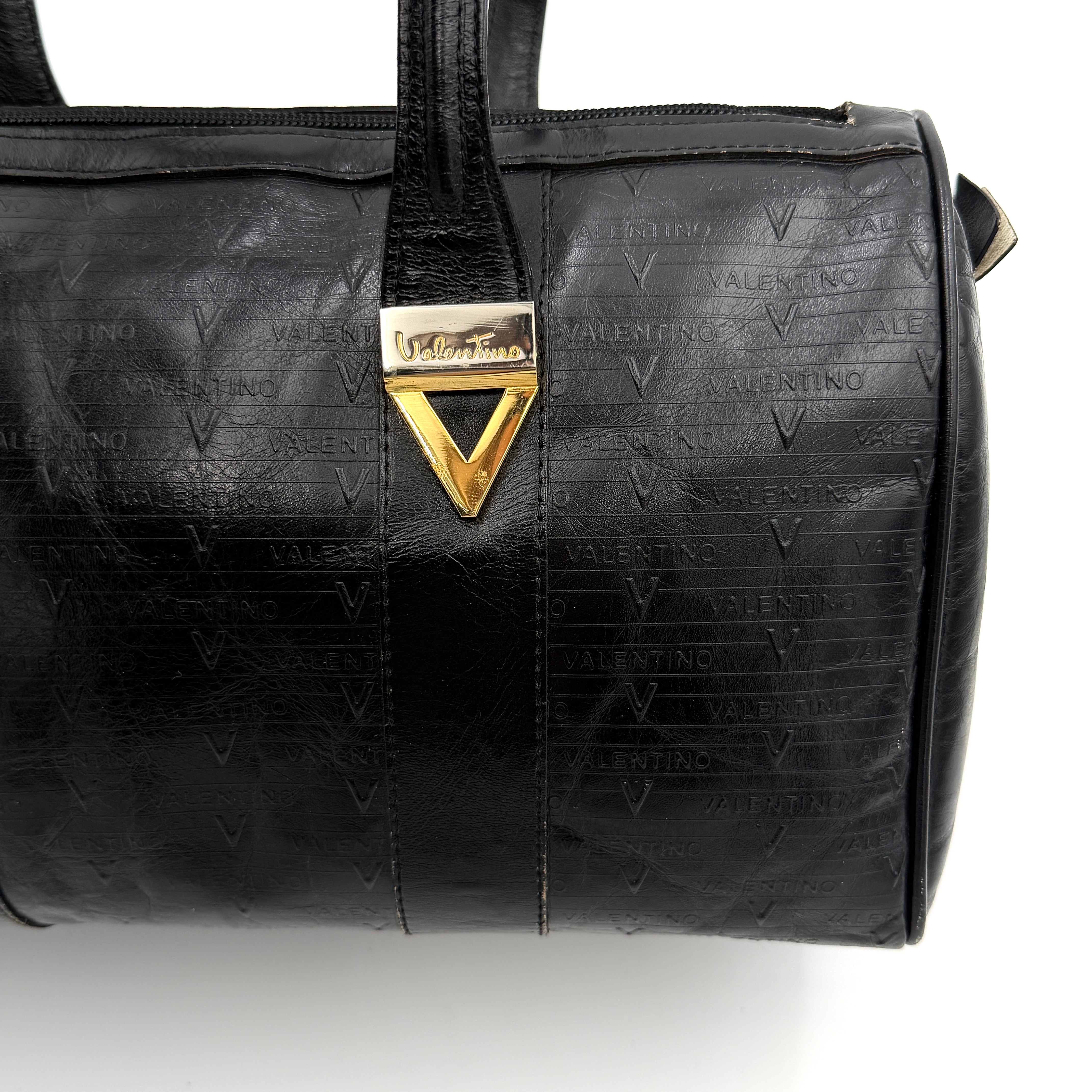 Valentino Monogram Boston Bag in black embossed leather with gold-tone V hardware and dual top handles.