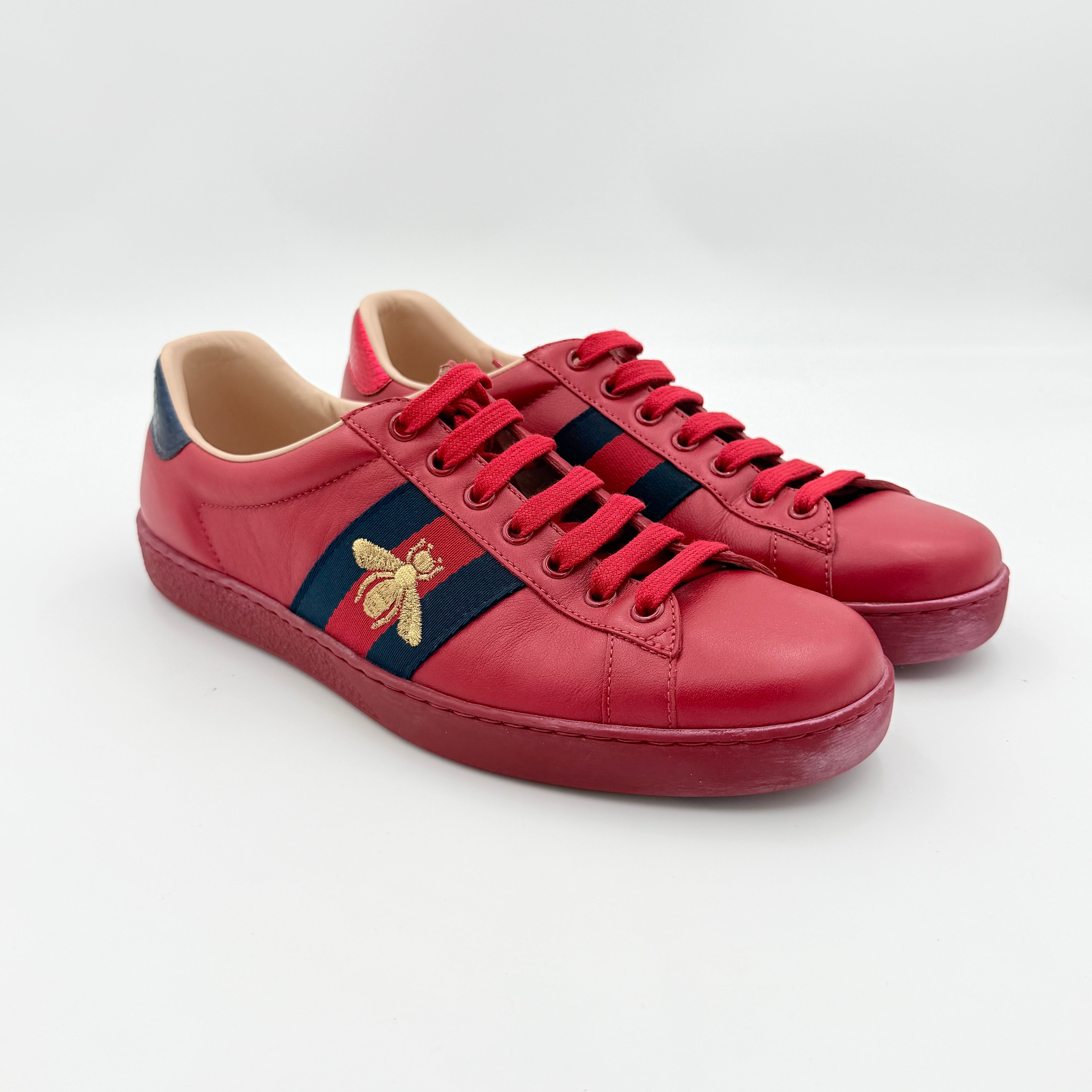 Gucci Ace Embroidered Bee sneakers in red leather with navy and red stripes and gold bee detail.