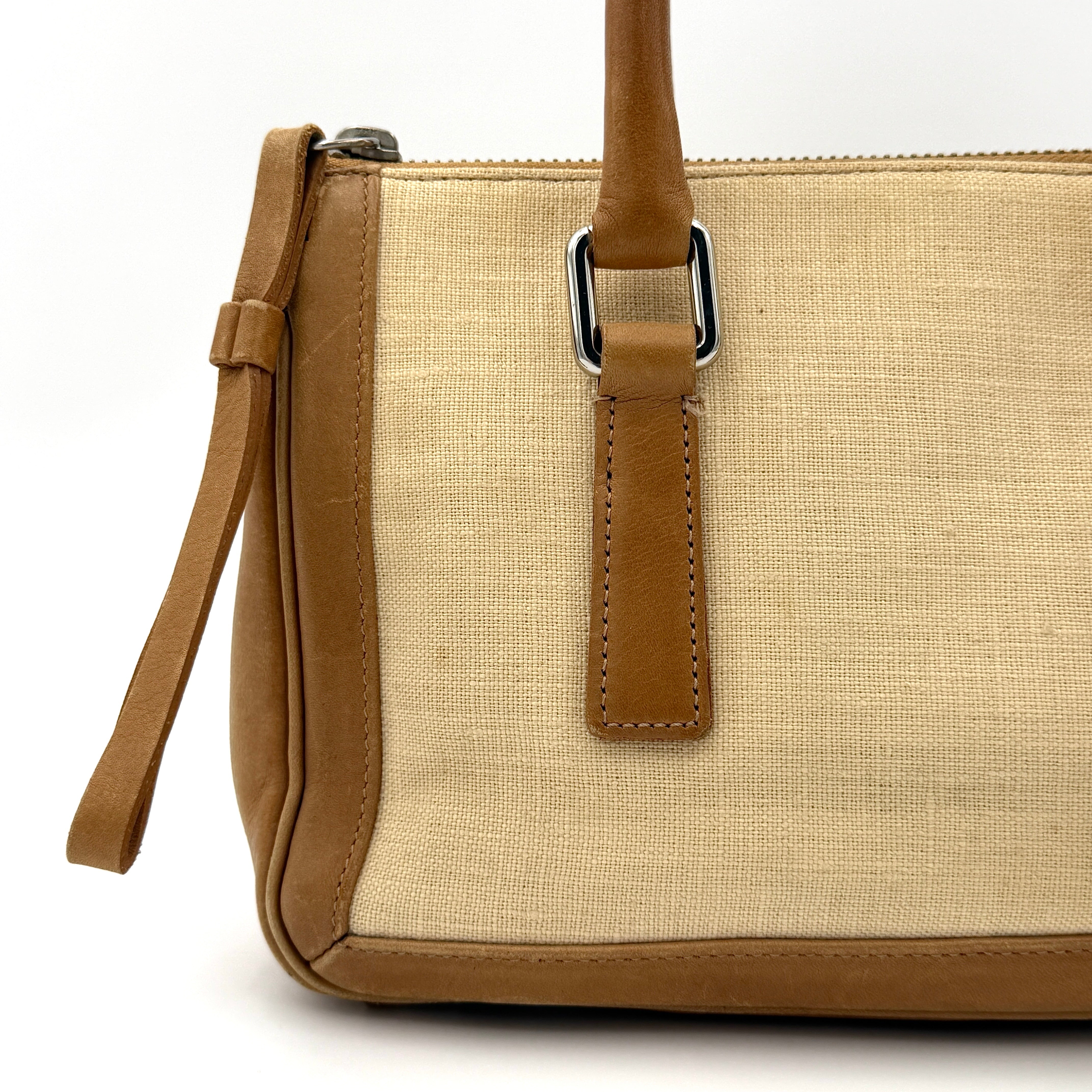 Coach Bonnie Legacy Satchel in beige canvas with caramel leather trim, structured silhouette and dual rolled handles.