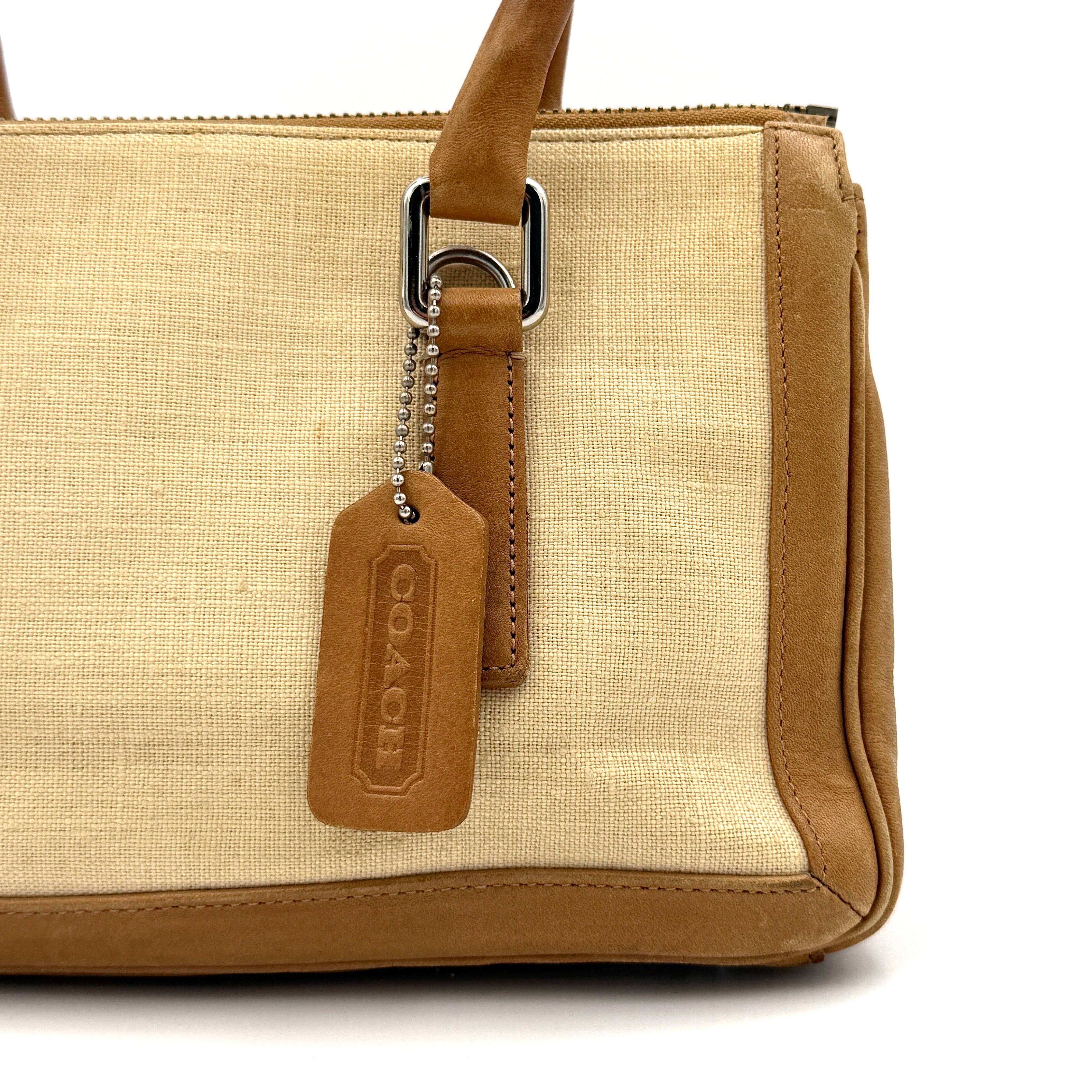 Coach Bonnie Legacy Satchel in beige canvas with caramel leather trim, structured silhouette and dual rolled handles.