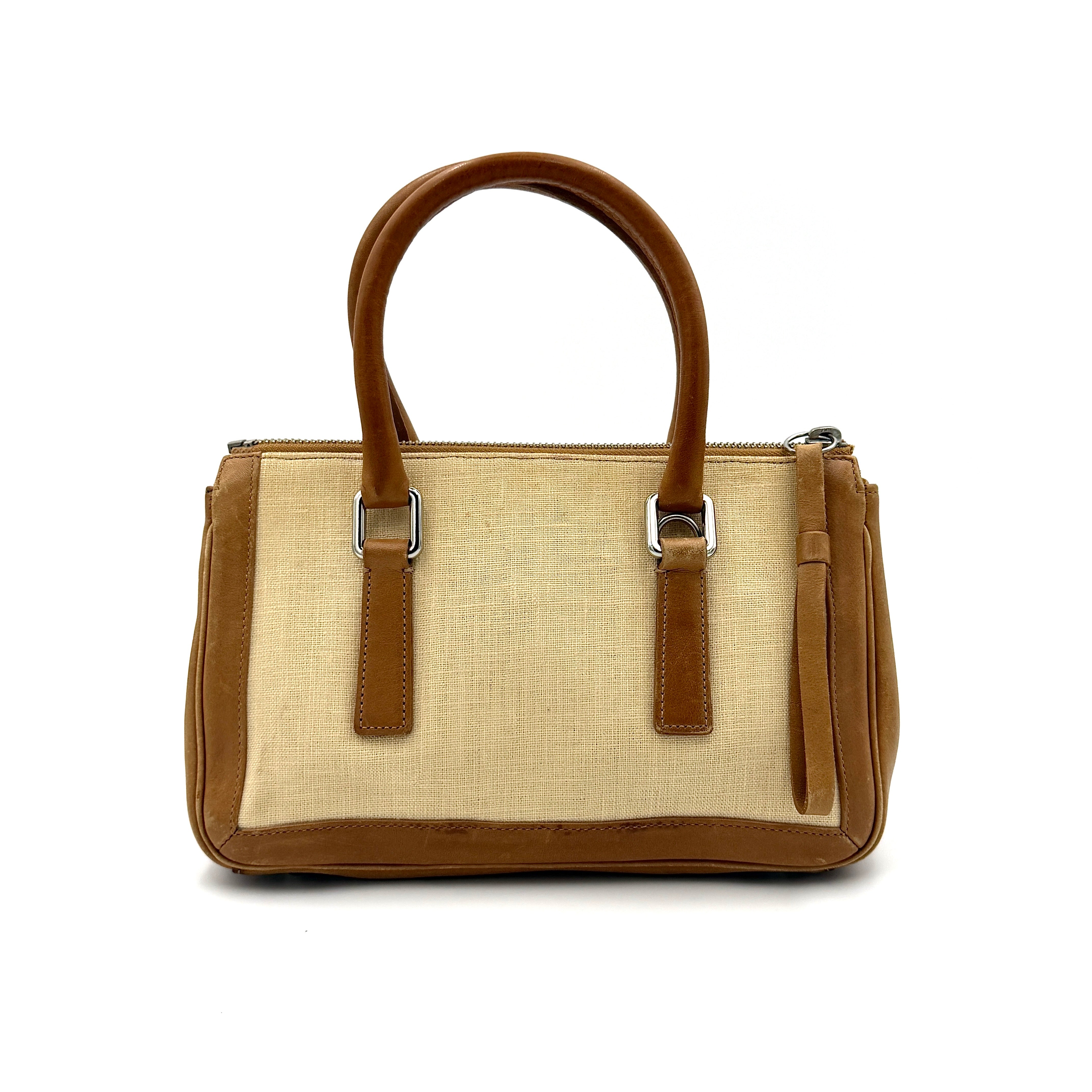 Coach Bonnie Legacy Satchel in beige canvas with caramel leather trim, structured silhouette and dual rolled handles.