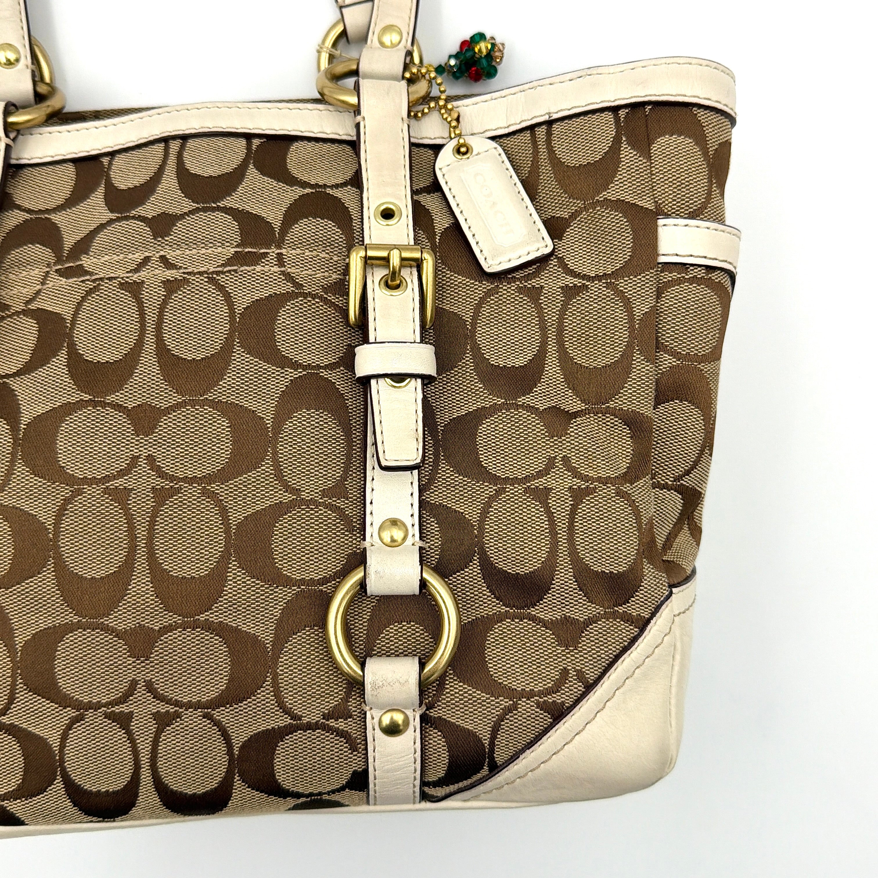 Coach Signature Gallery Tote Bag in beige jacquard canvas with cream leather trim, belted accents, and gold-tone hardware.