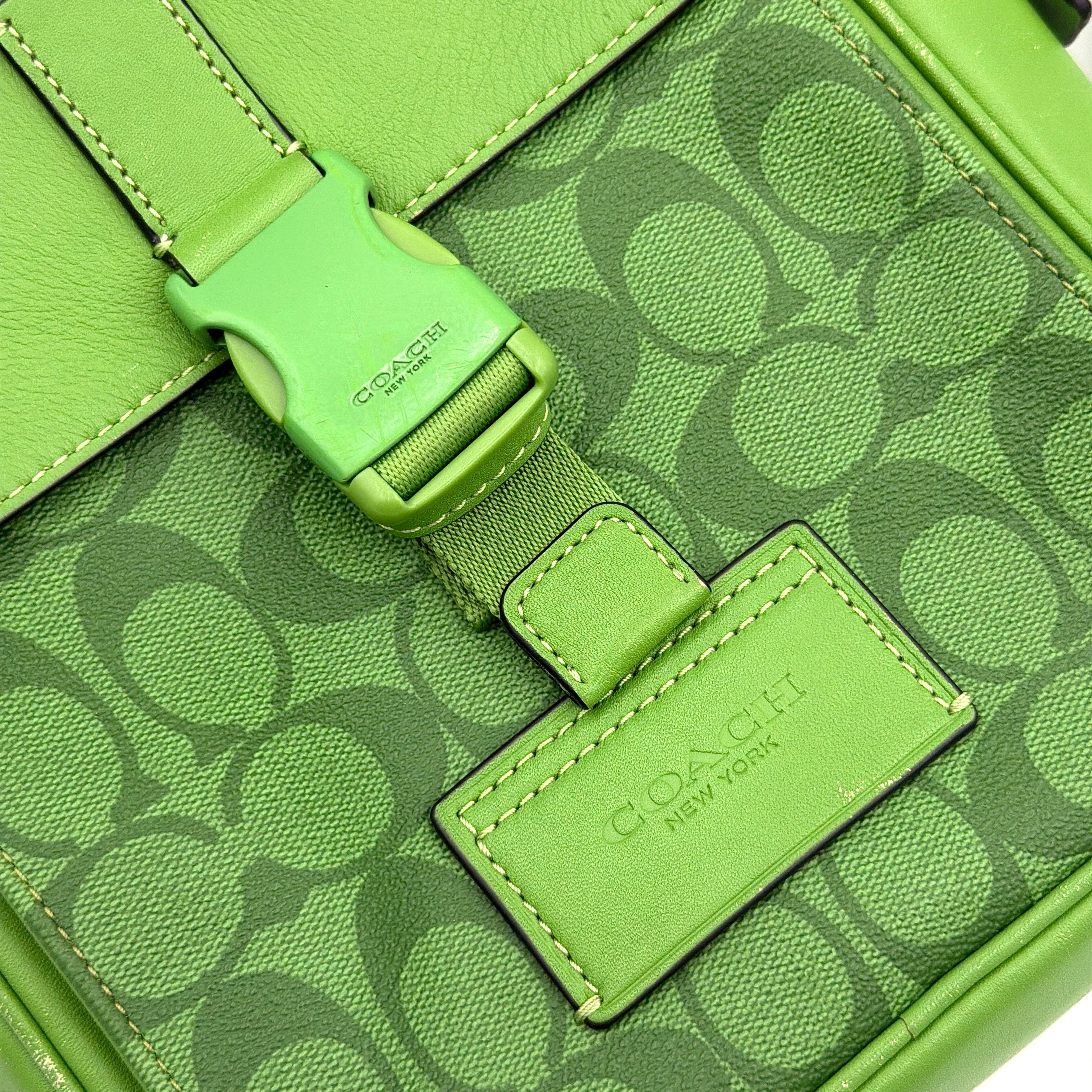 Coach Signature Canvas Track Pack Crossbody Bag in vibrant green with tonal green hardware and adjustable strap set against a clean background.