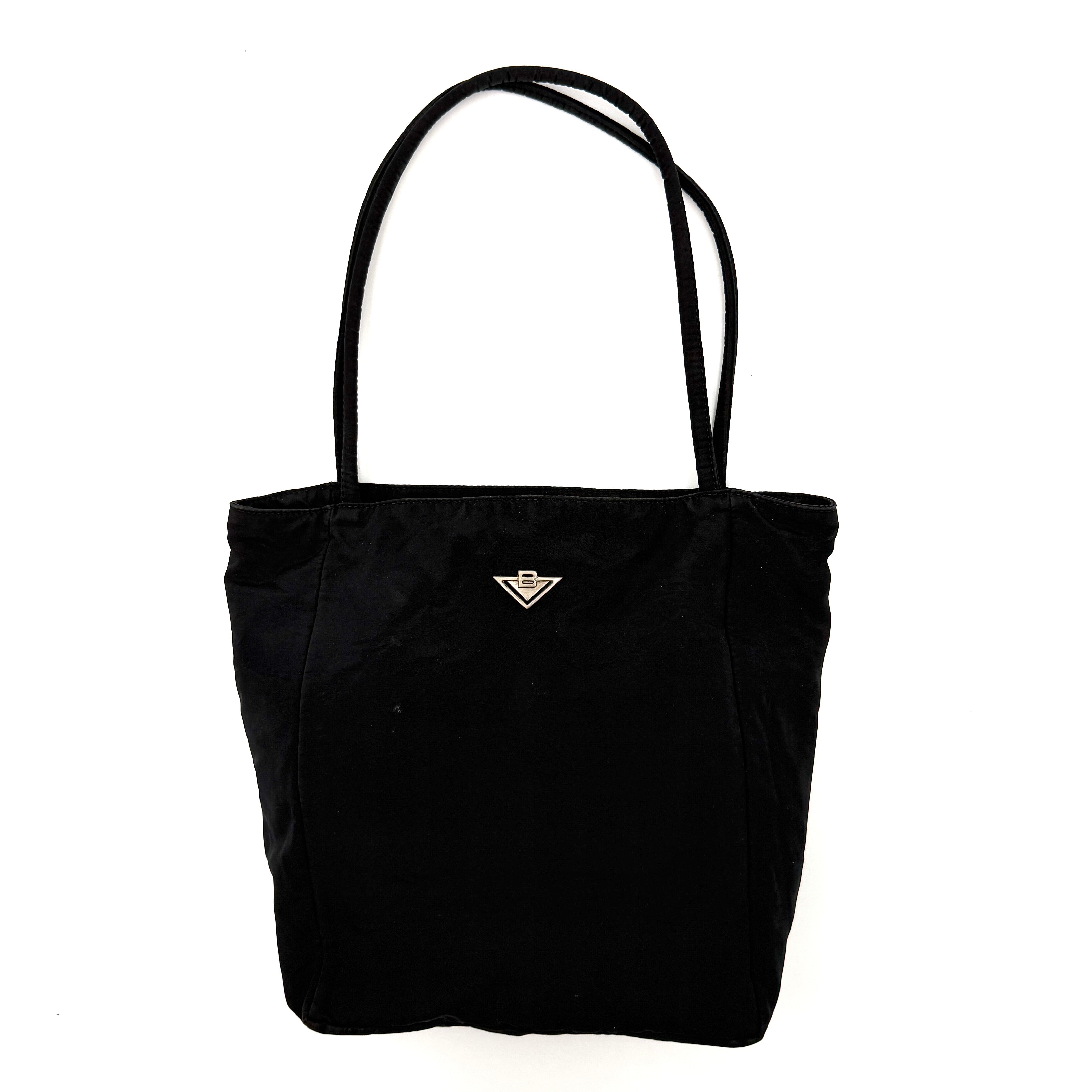 Bottega Veneta black nylon tote with structured double handles and a pale gold-tone logo plaque at the front.