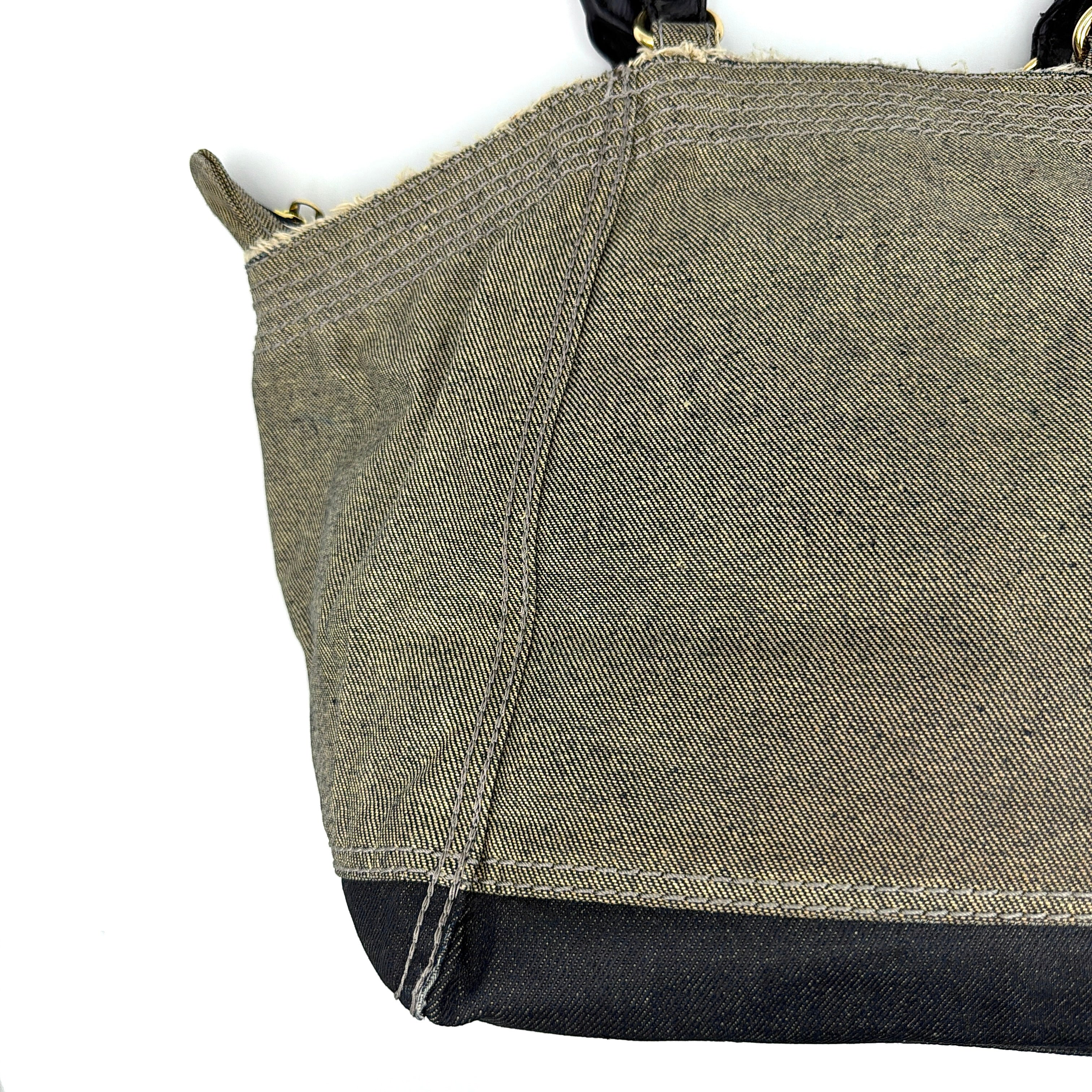 Diesel washed denim shoulder bag with black leather handles, gold zips and frayed edge detail.