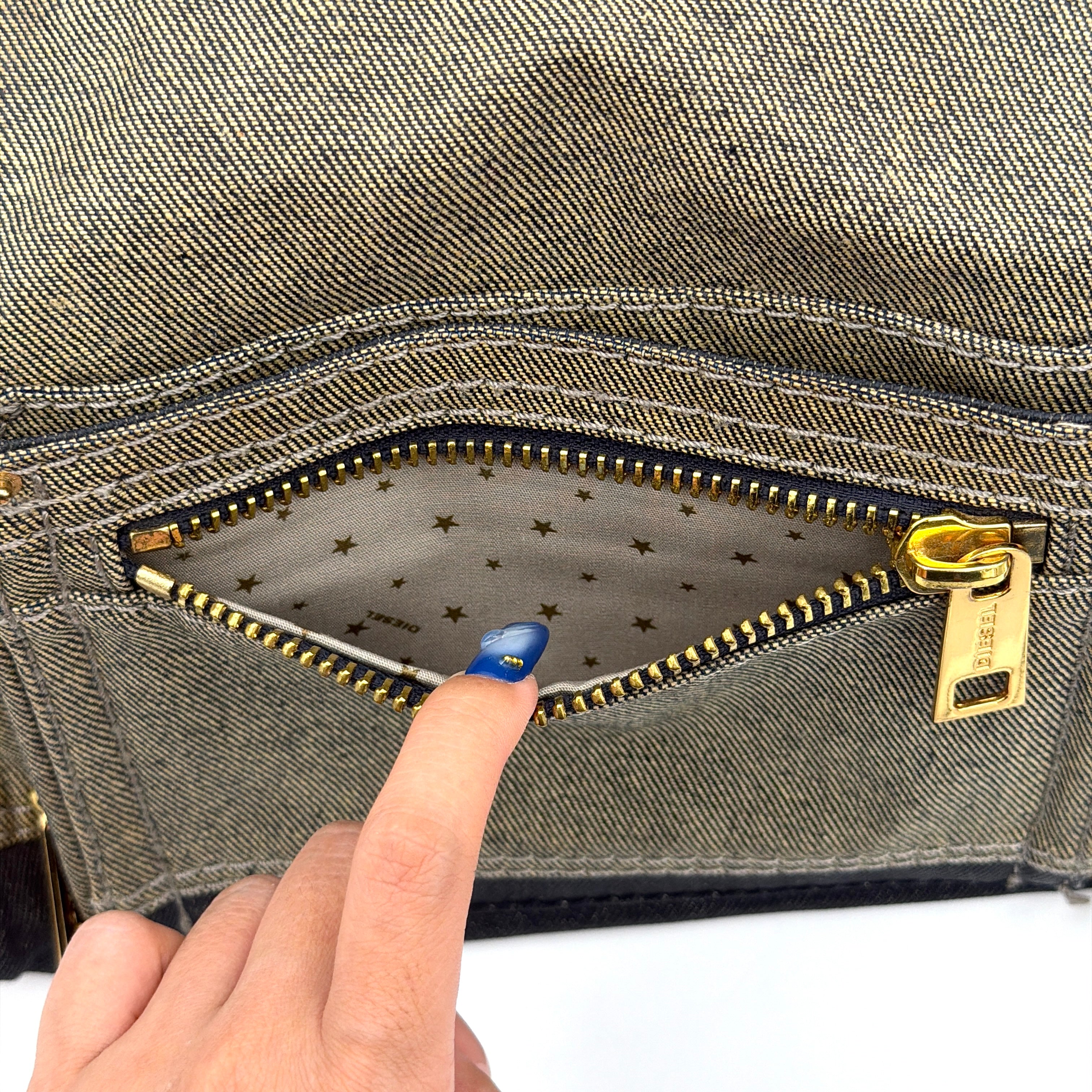 Diesel washed denim shoulder bag with black leather handles, gold zips and frayed edge detail.