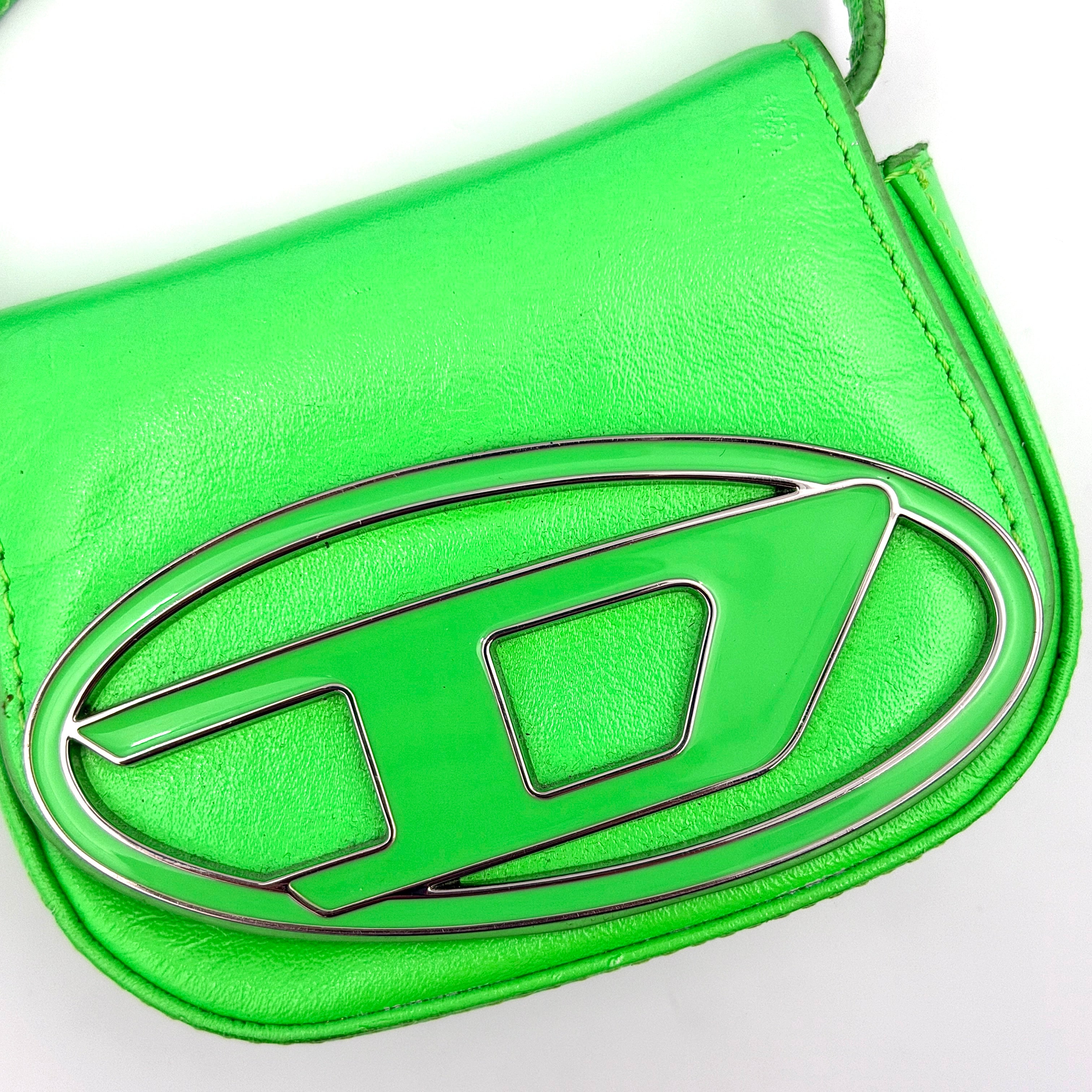 Diesel 1DR-XS Mini Bag in vivid neon green leather with bold silver D plaque and detachable strap, presented against a clean background.