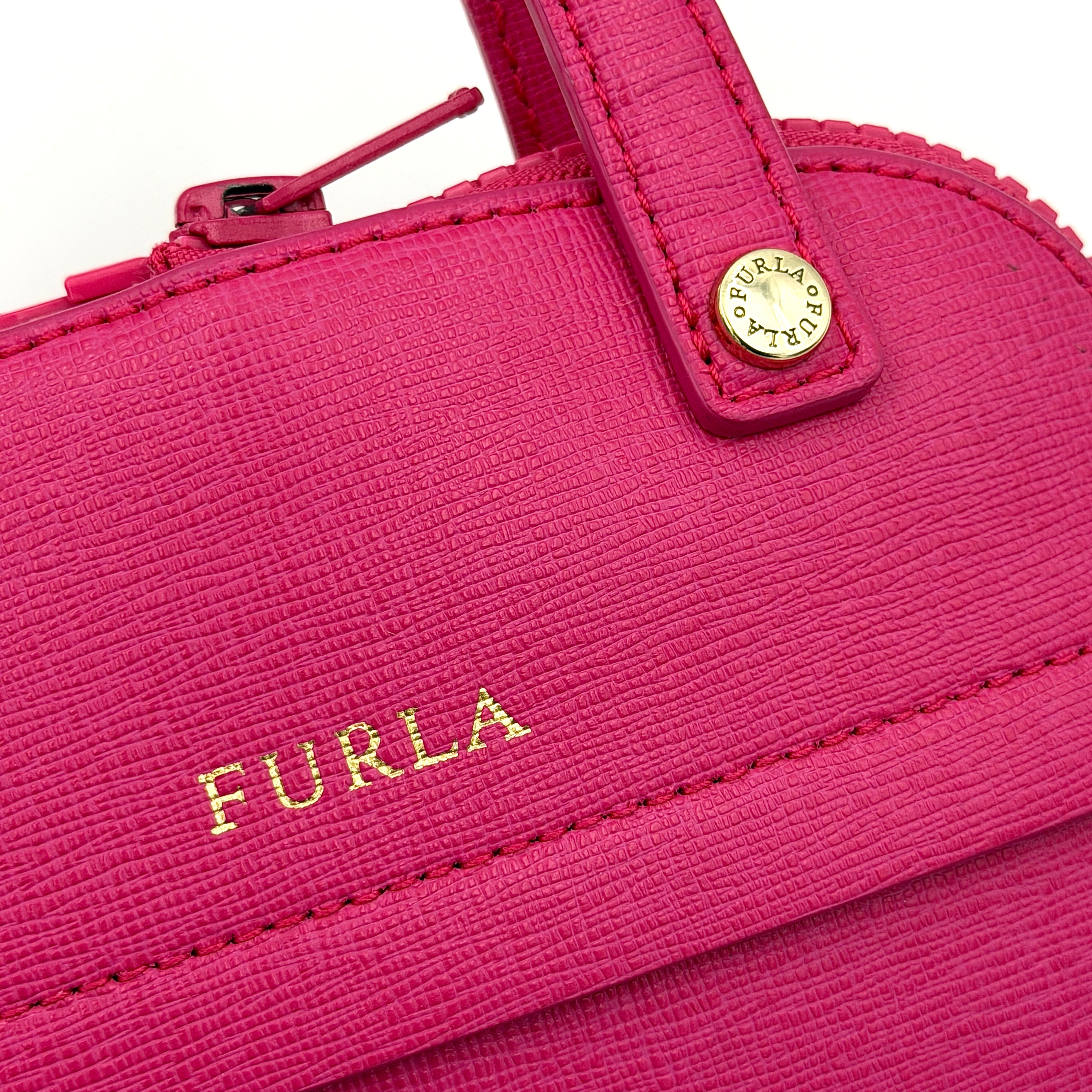 Furla black nylon tote bag with a bold pink zip pouch detail, styled as an exterior pocket, displayed flat to showcase its silhouette.