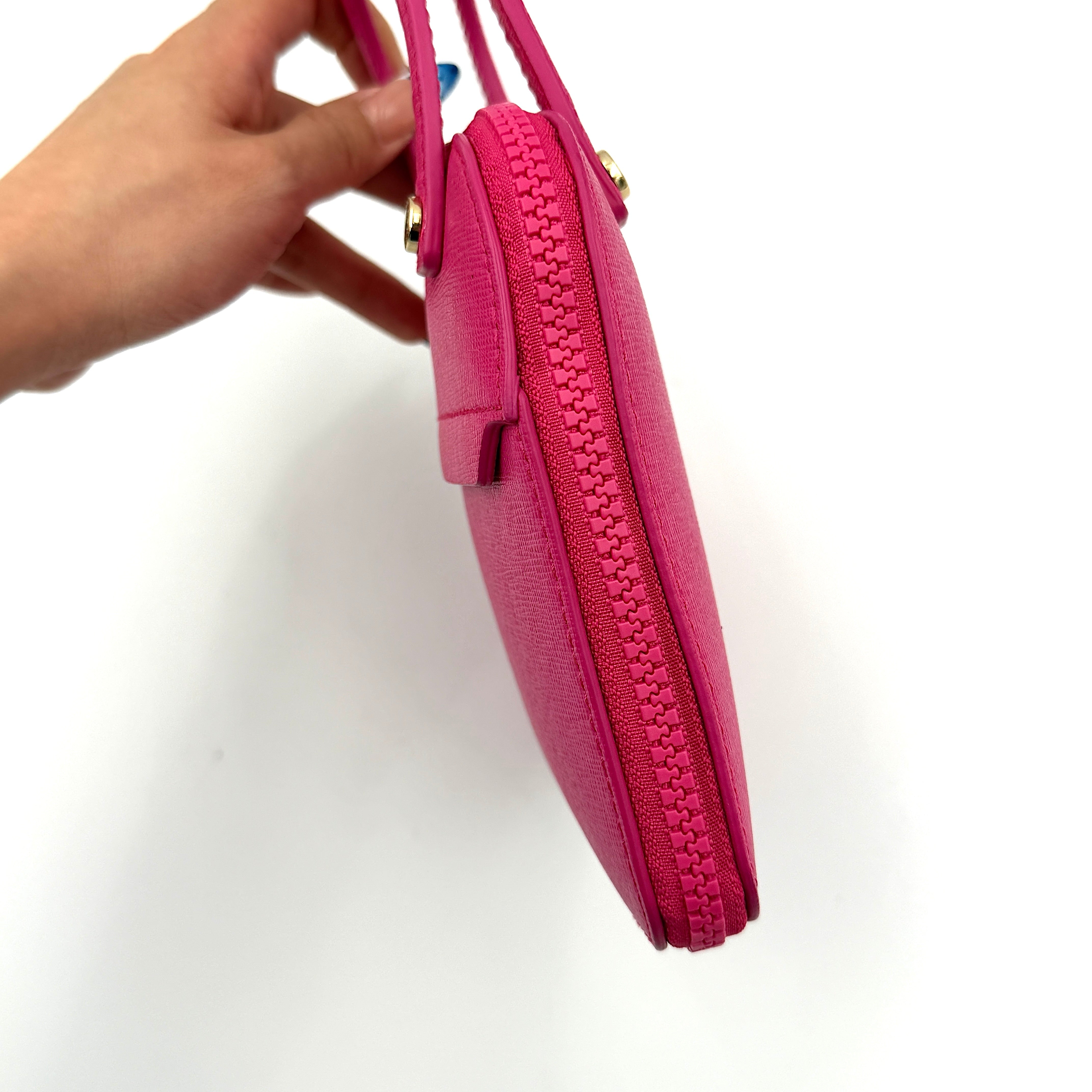 Furla black nylon tote bag with a bold pink zip pouch detail, styled as an exterior pocket, displayed flat to showcase its silhouette.