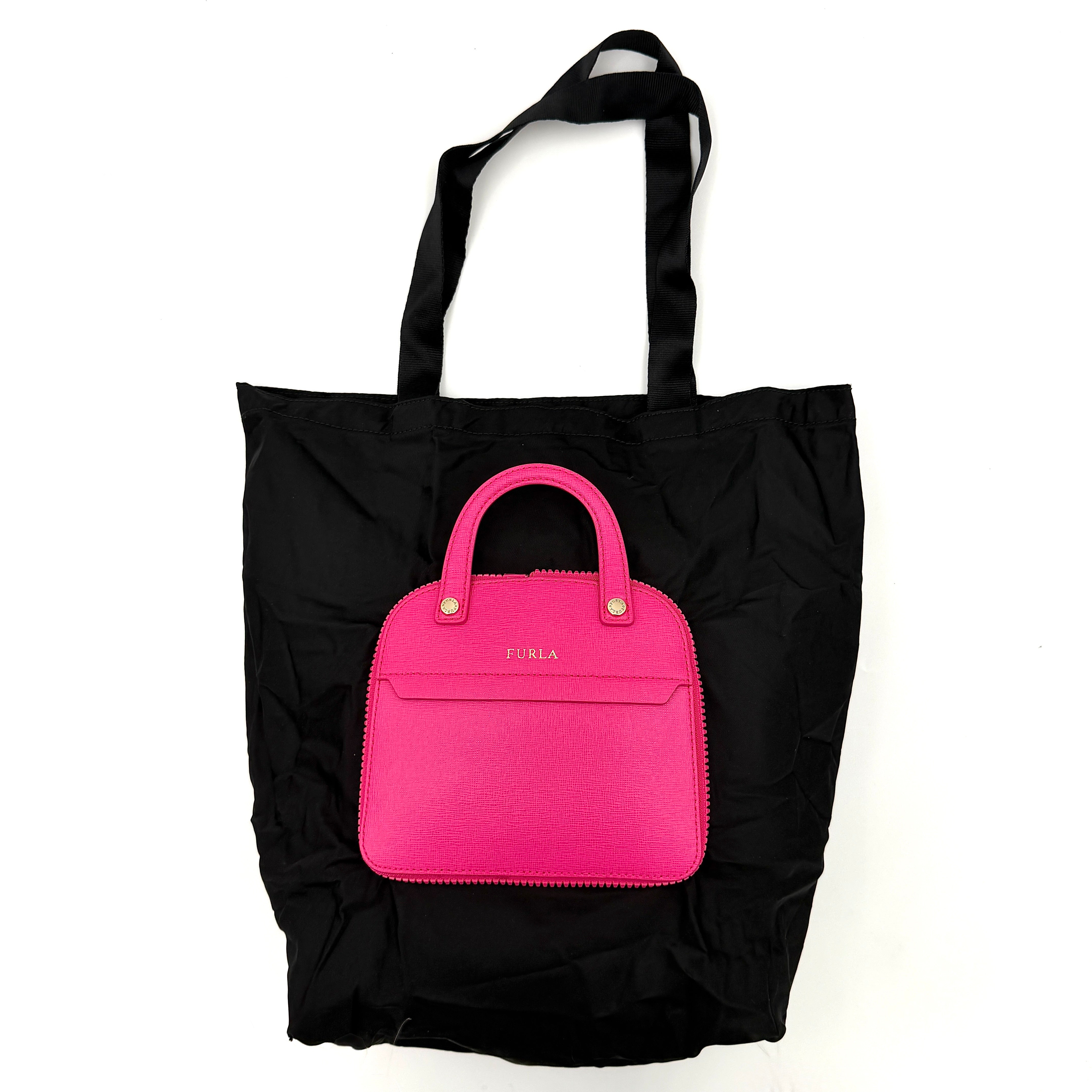 Furla black nylon tote bag with a bold pink zip pouch detail, styled as an exterior pocket, displayed flat to showcase its silhouette.
