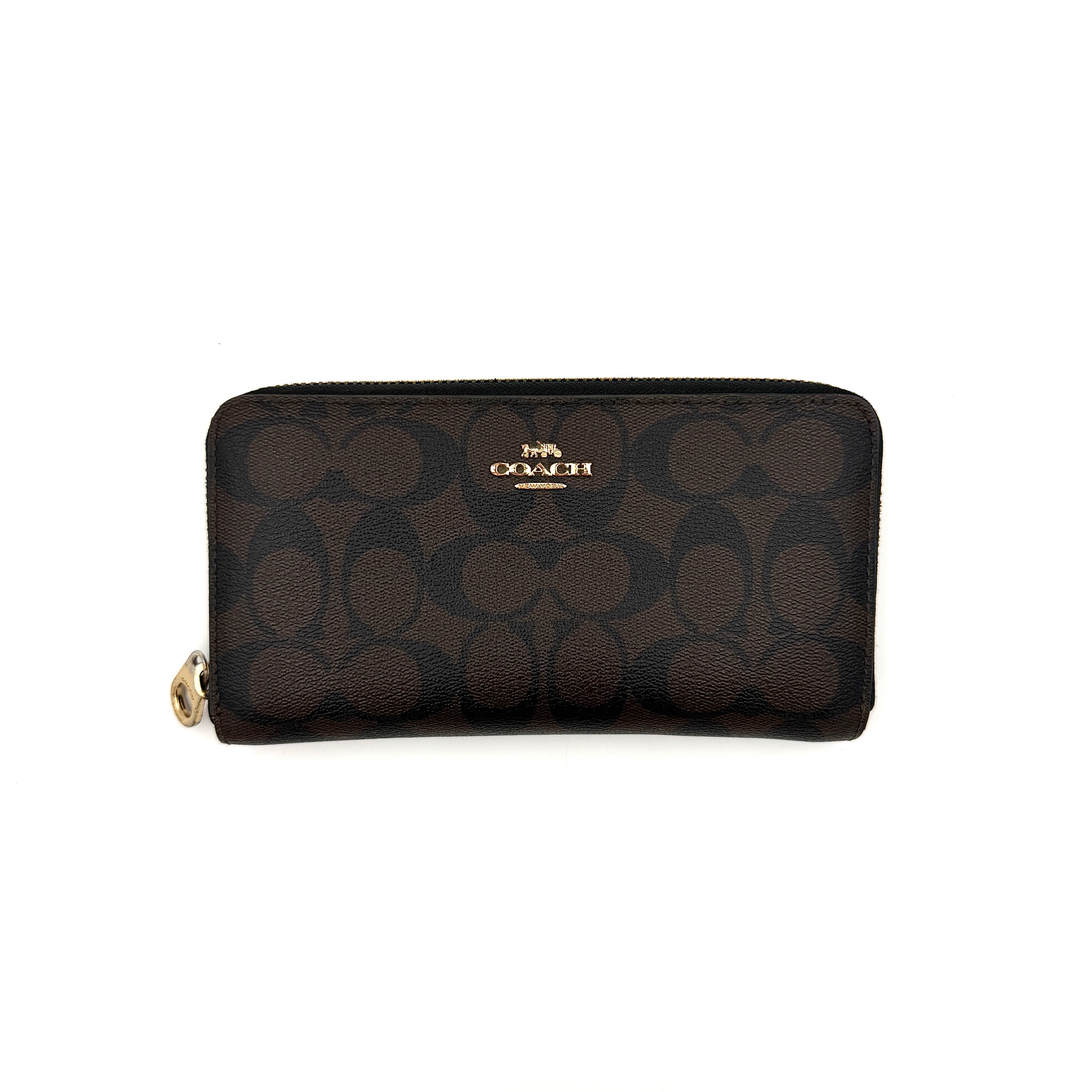 Coach Signature Canvas long wallet in brown monogram with gold zip and logo, shown from the front against a clean background.