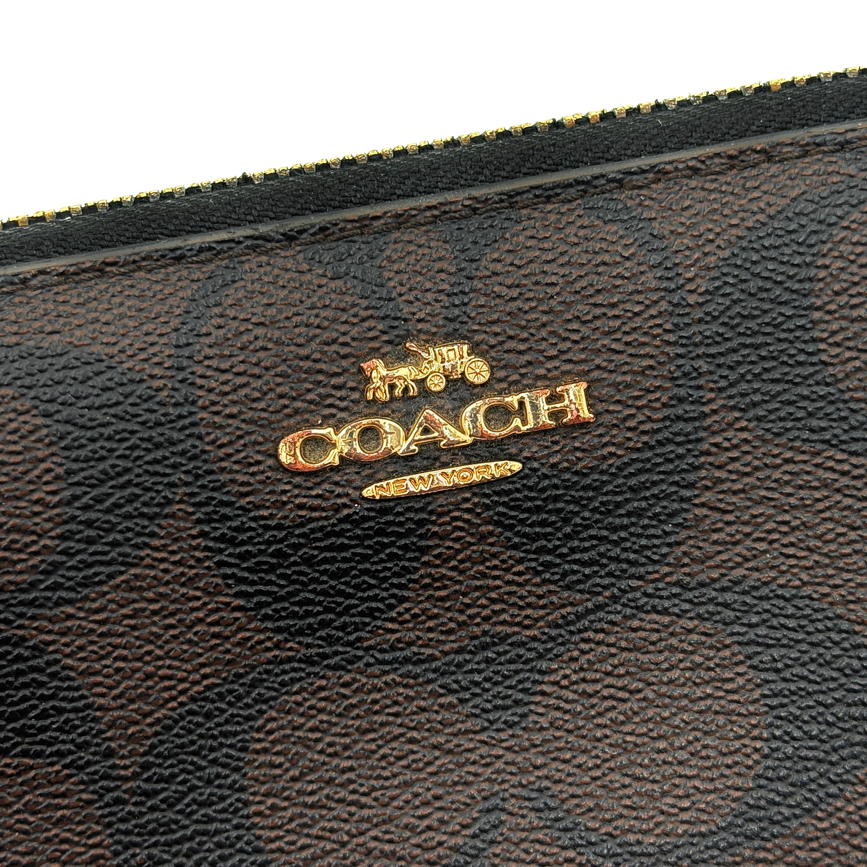 Coach Signature Canvas long wallet in brown monogram with gold zip and logo, shown from the front against a clean background.