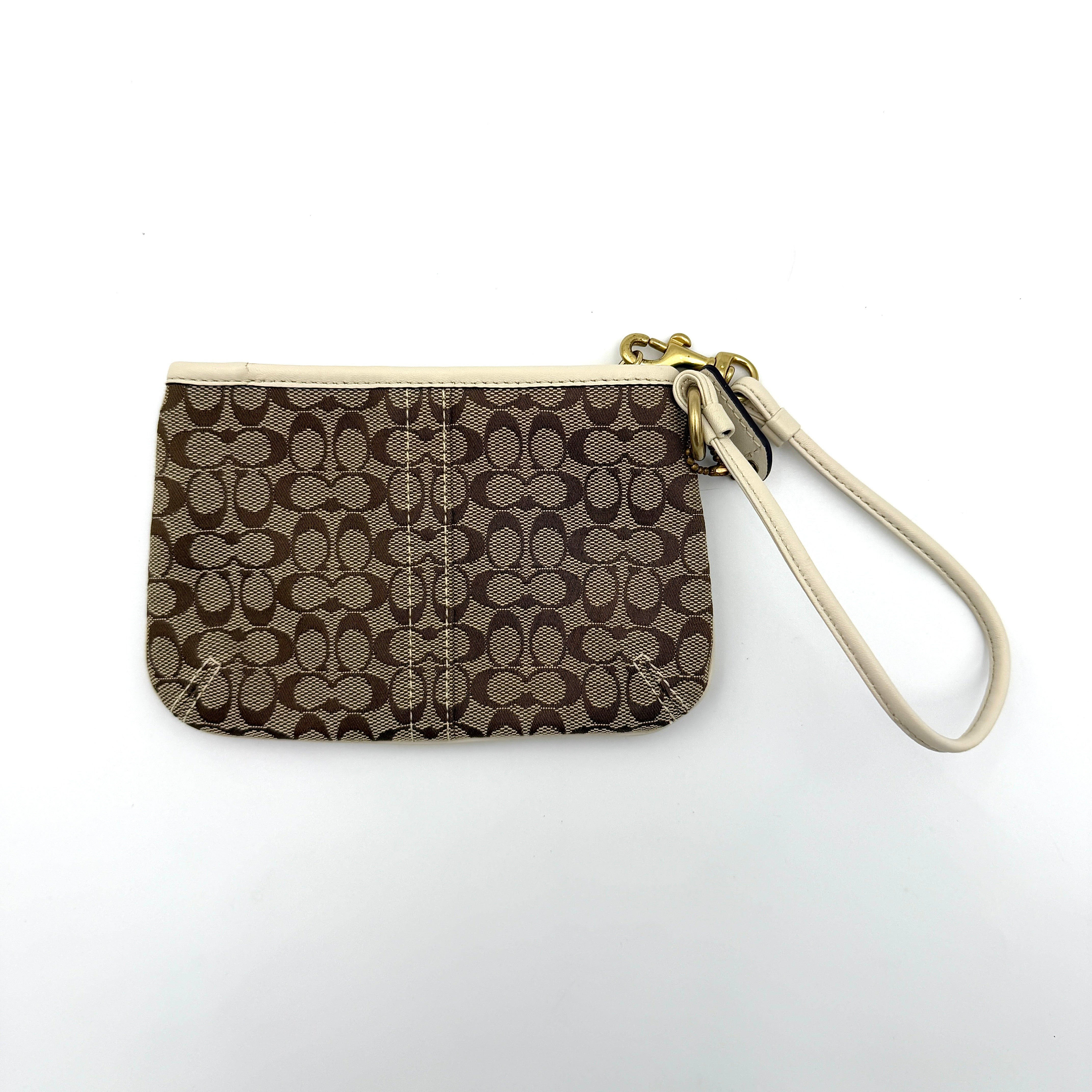 Coach Signature Canvas Wristlet in brown and ivory leather with gold-tone hardware and detachable wrist strap.