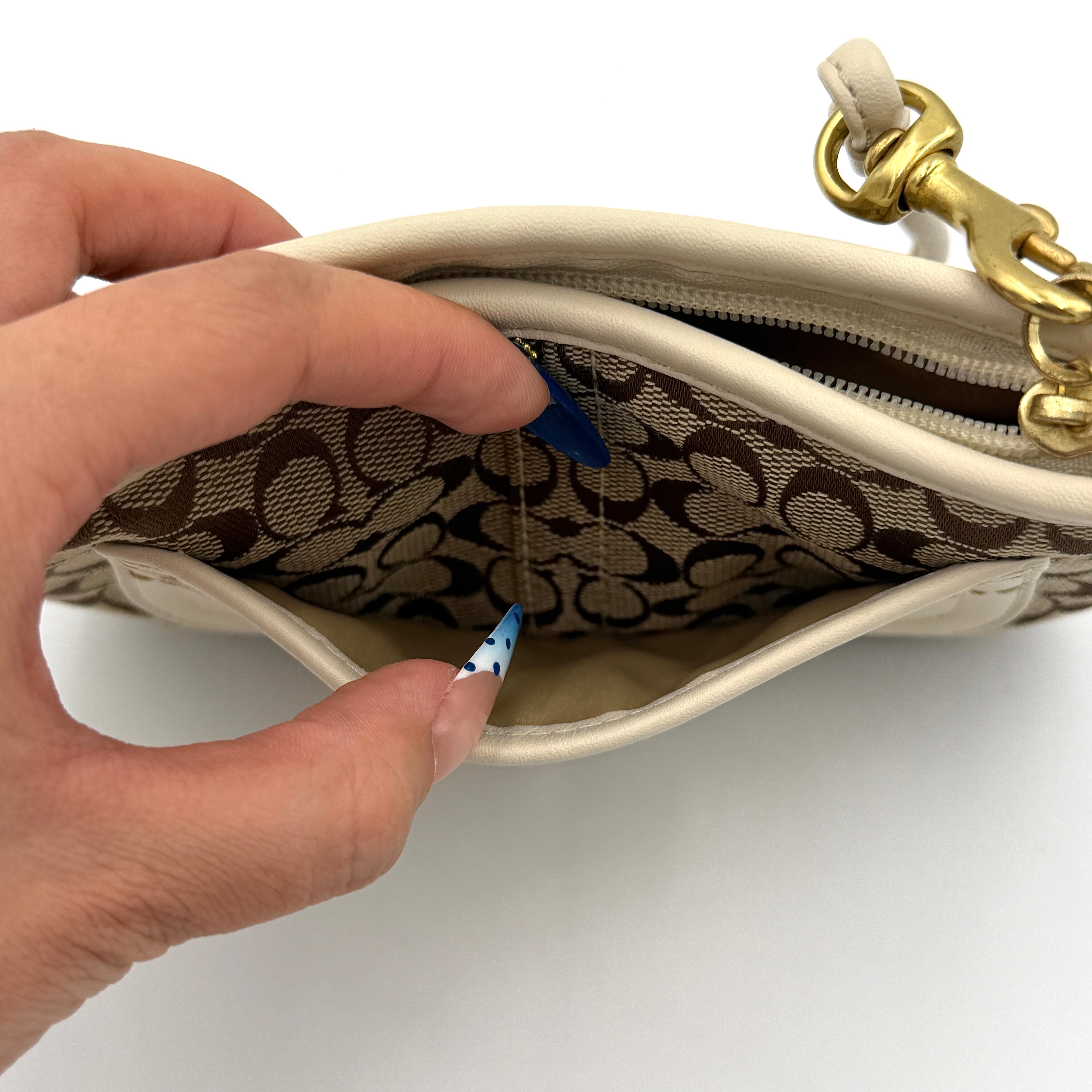 Coach Signature Canvas Wristlet in brown and ivory leather with gold-tone hardware and detachable wrist strap.