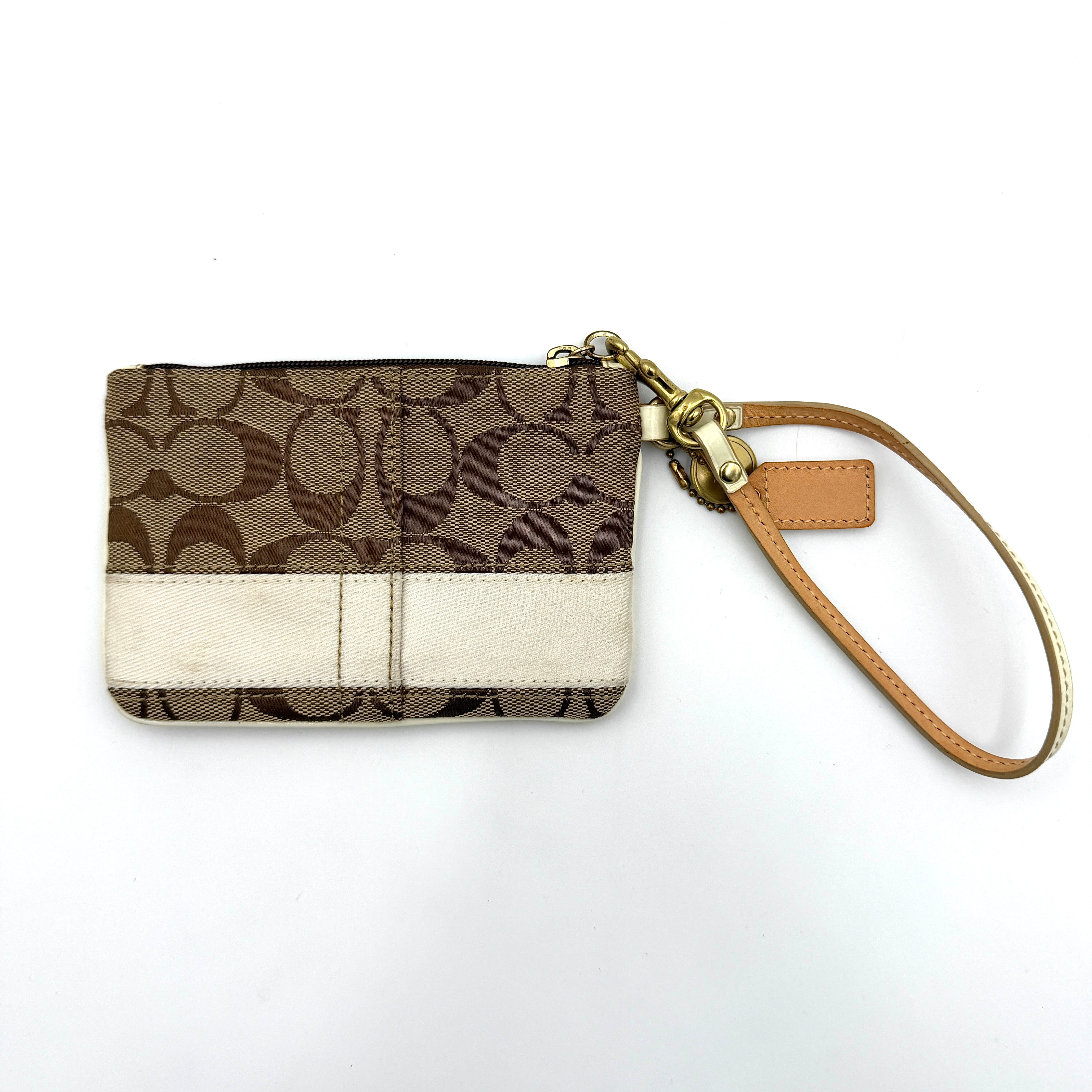 Coach Signature Stripe Wristlet in beige and cream jacquard, accented with a cream leather strap and gold-tone hardware.