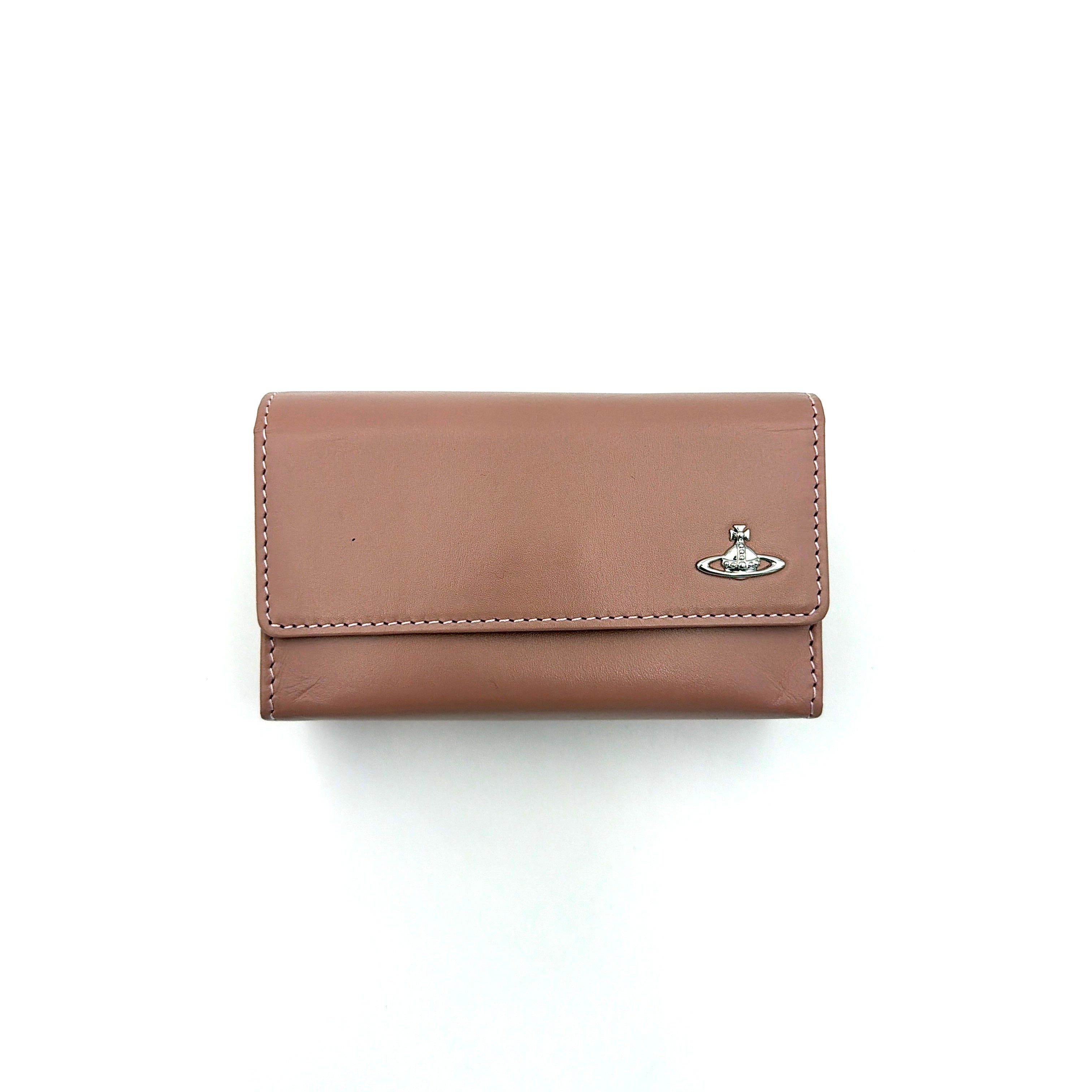 Vivienne Westwood pink leather wallet with silver signature Orb hardware, styled against a clean background.