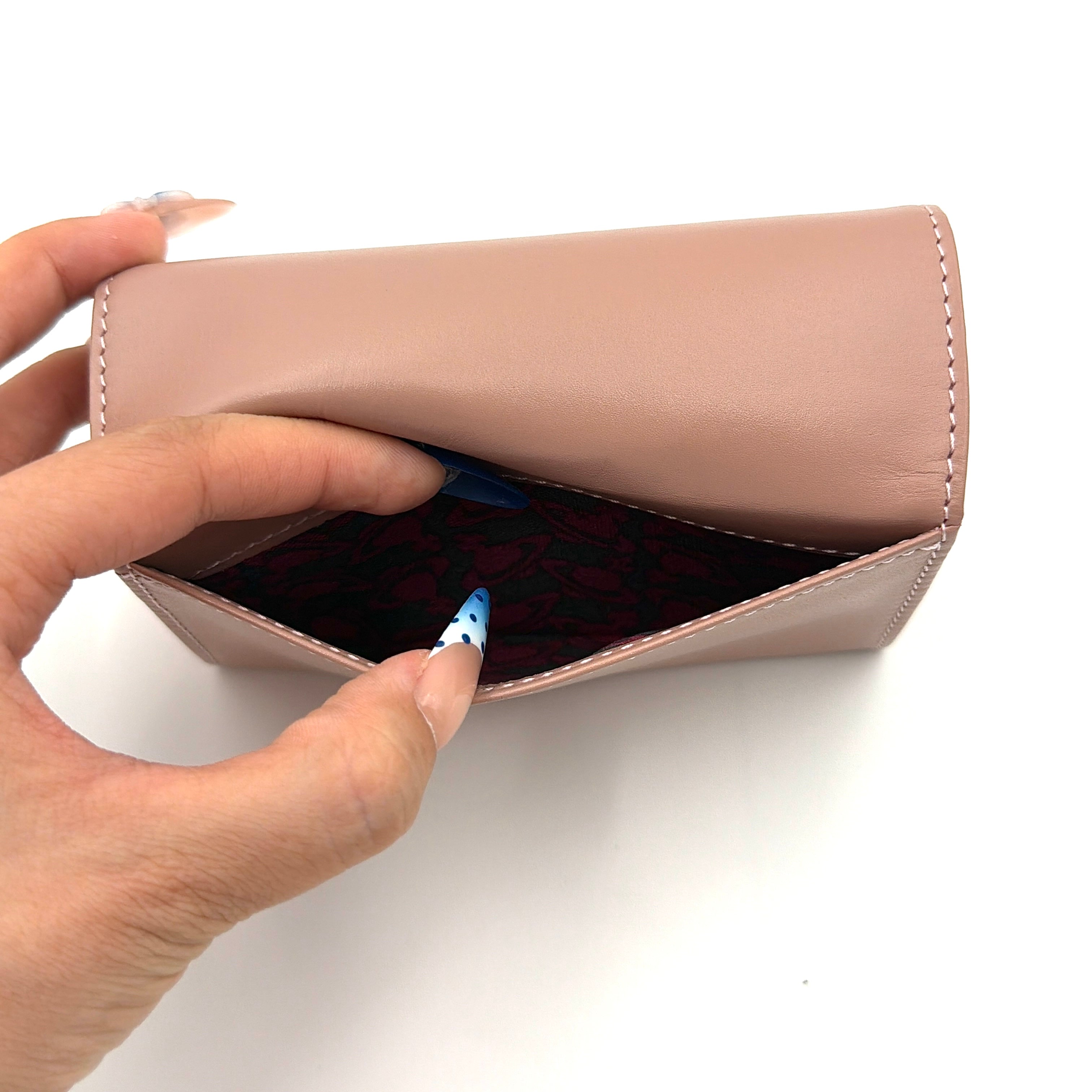 Vivienne Westwood pink leather wallet with silver signature Orb hardware, styled against a clean background.