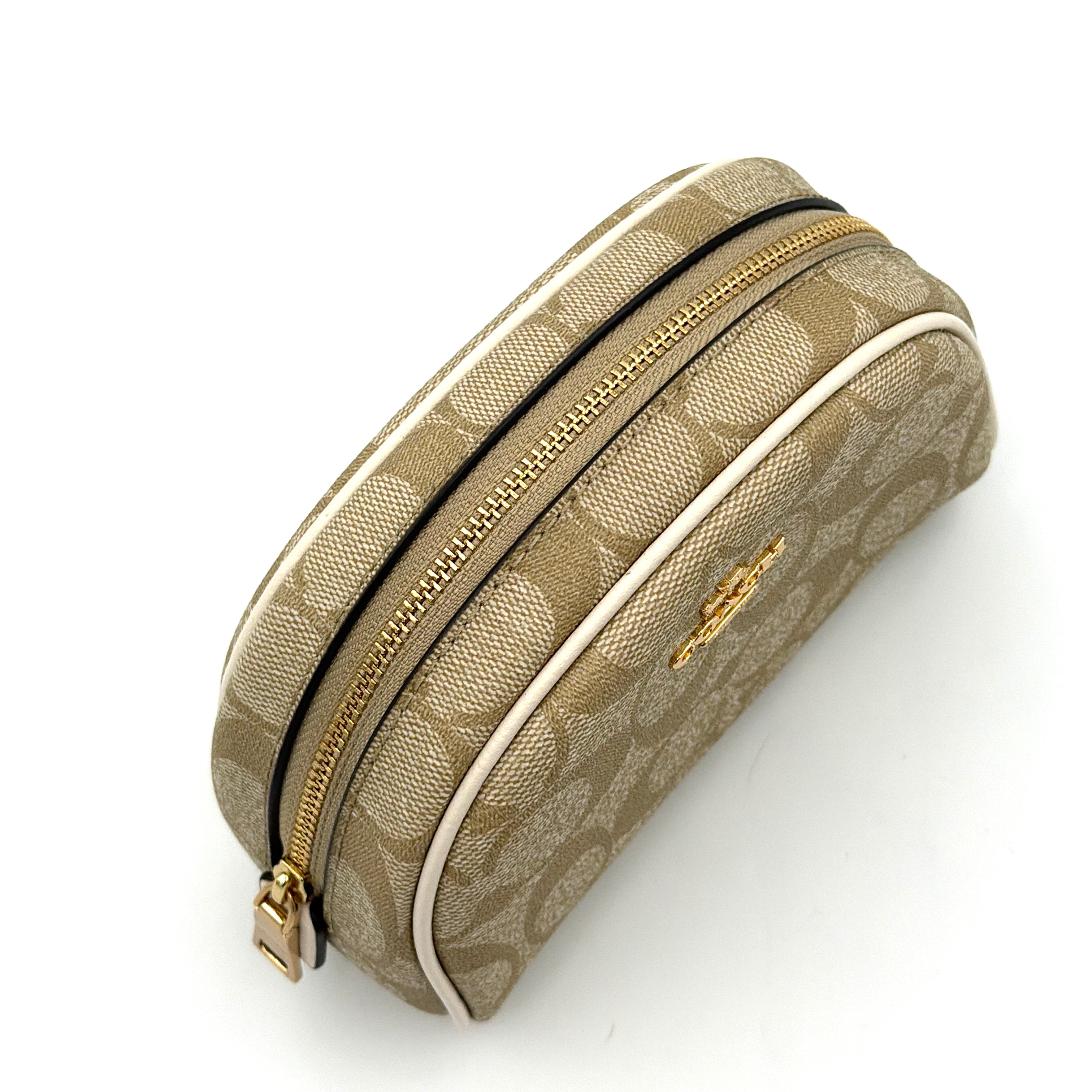 Coach Signature Canvas Dome Cosmetic Case in beige monogram canvas with gold hardware and curved silhouette.