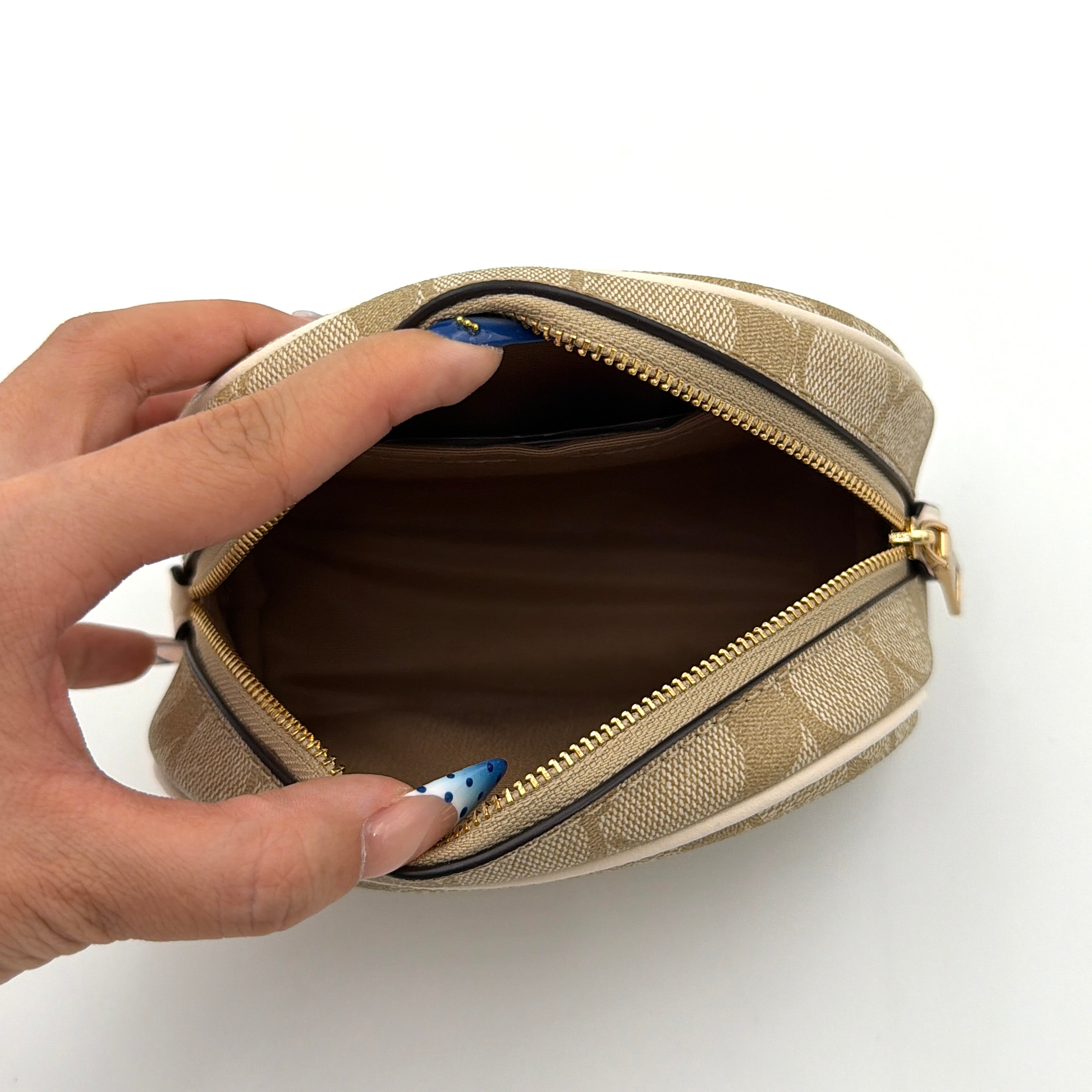Coach Signature Canvas Dome Cosmetic Case in beige monogram canvas with gold hardware and curved silhouette.