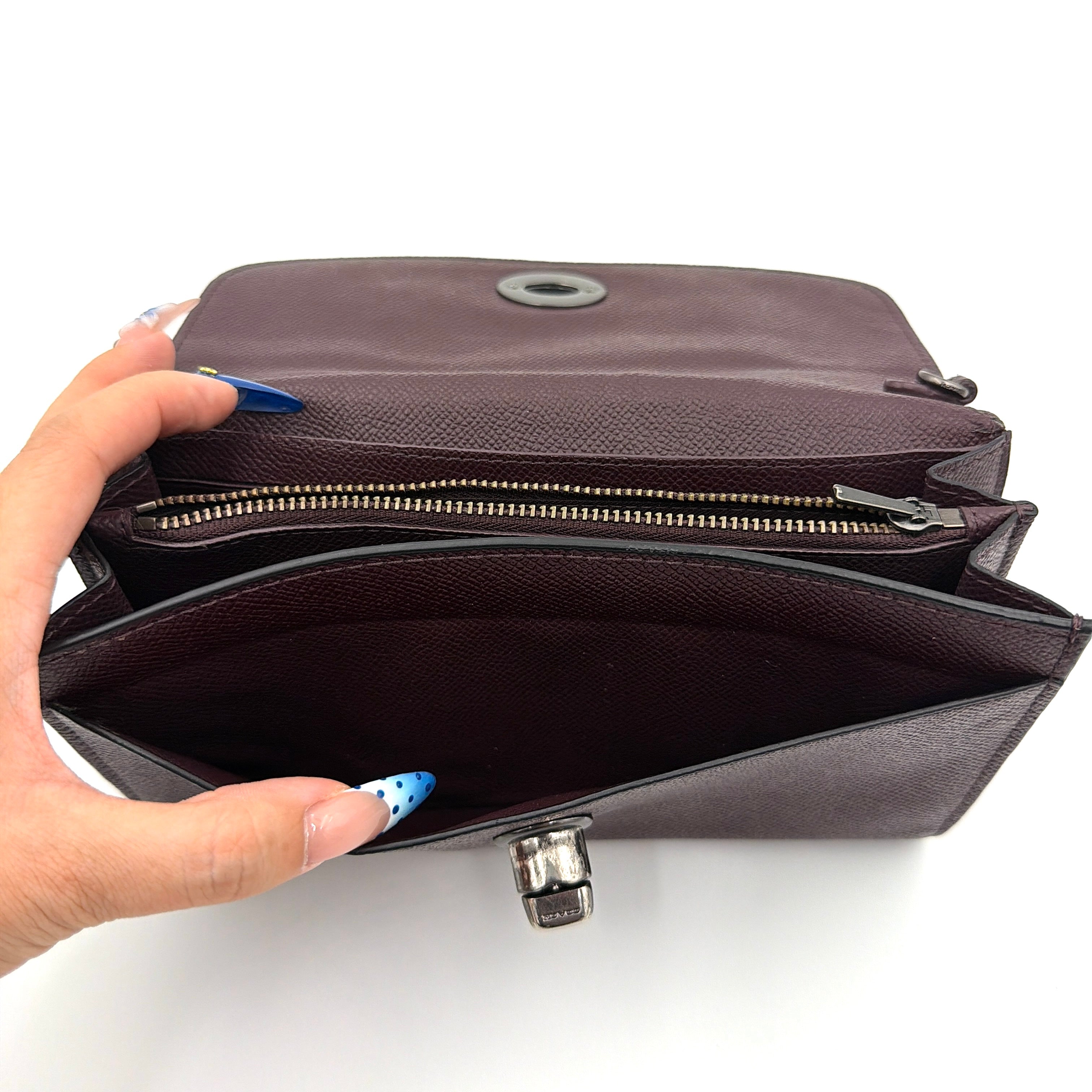 Coach Bear Turnlock Clutch in burgundy leather with playful pink and silver star details and signature gunmetal turnlock front closure.