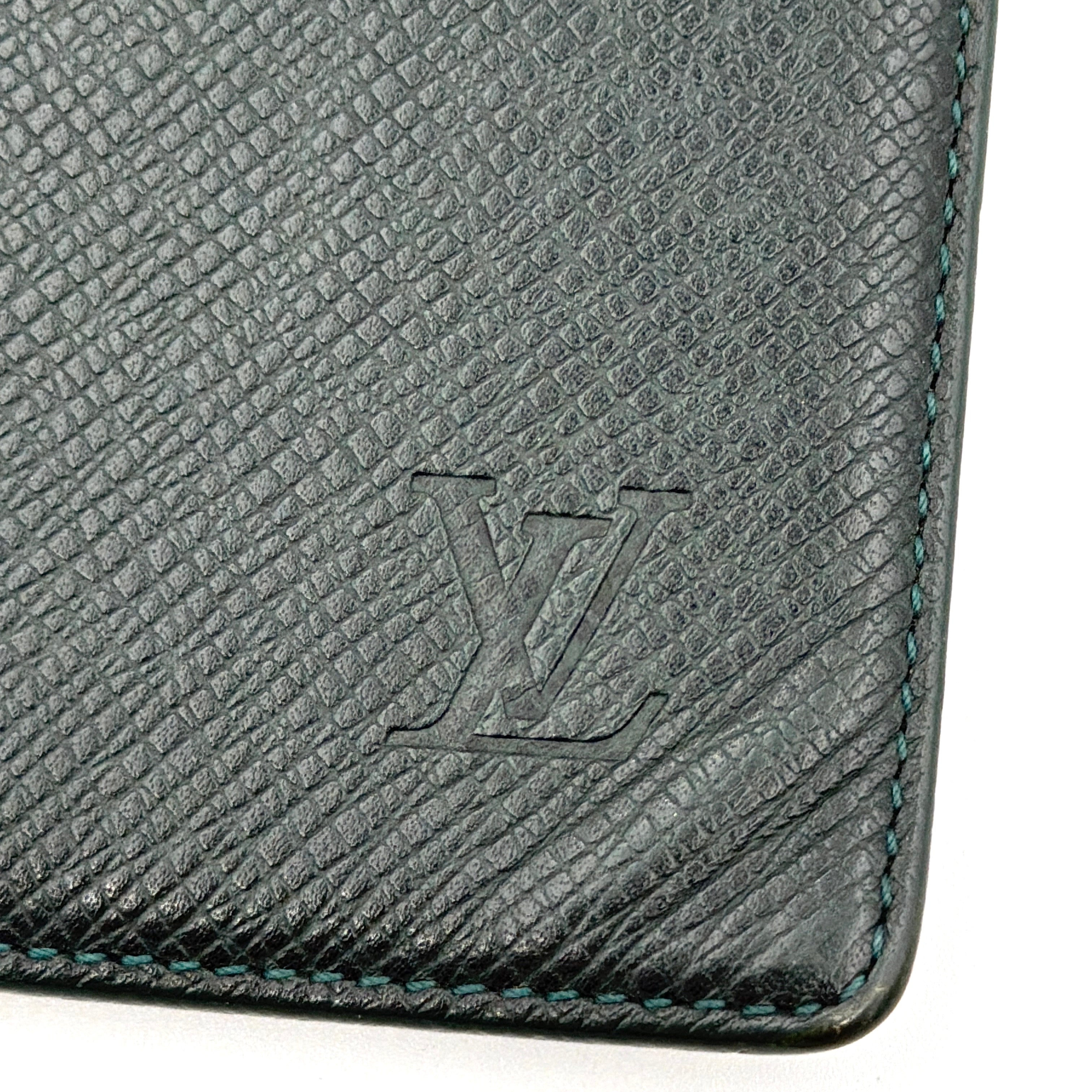 Louis Vuitton Taiga Brazza Wallet in dark green Taiga leather, showcasing a textured finish and iconic LV embossing in the bottom corner.