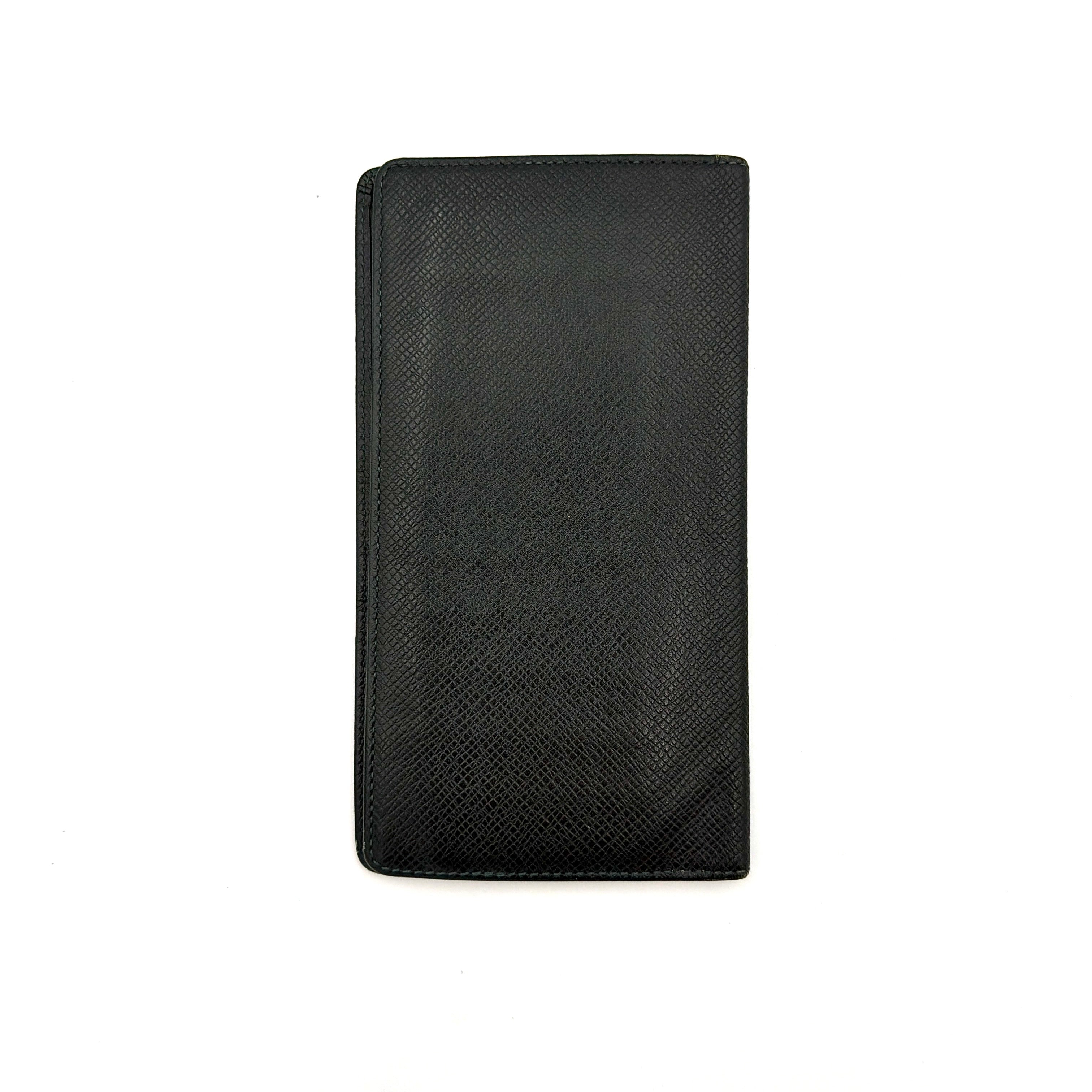 Louis Vuitton Taiga Brazza Wallet in dark green Taiga leather, showcasing a textured finish and iconic LV embossing in the bottom corner.