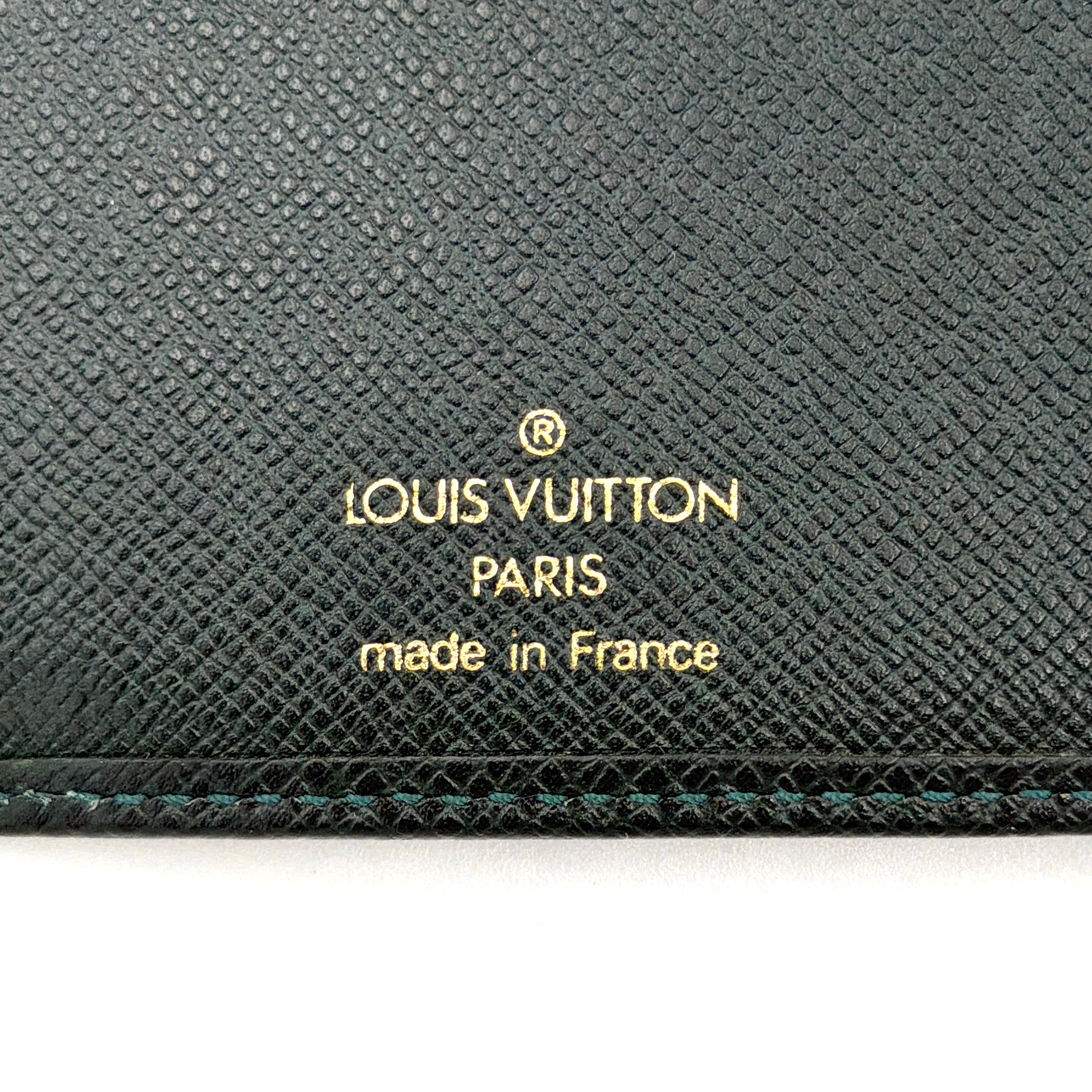 Louis Vuitton Taiga Brazza Wallet in dark green Taiga leather, showcasing a textured finish and iconic LV embossing in the bottom corner.