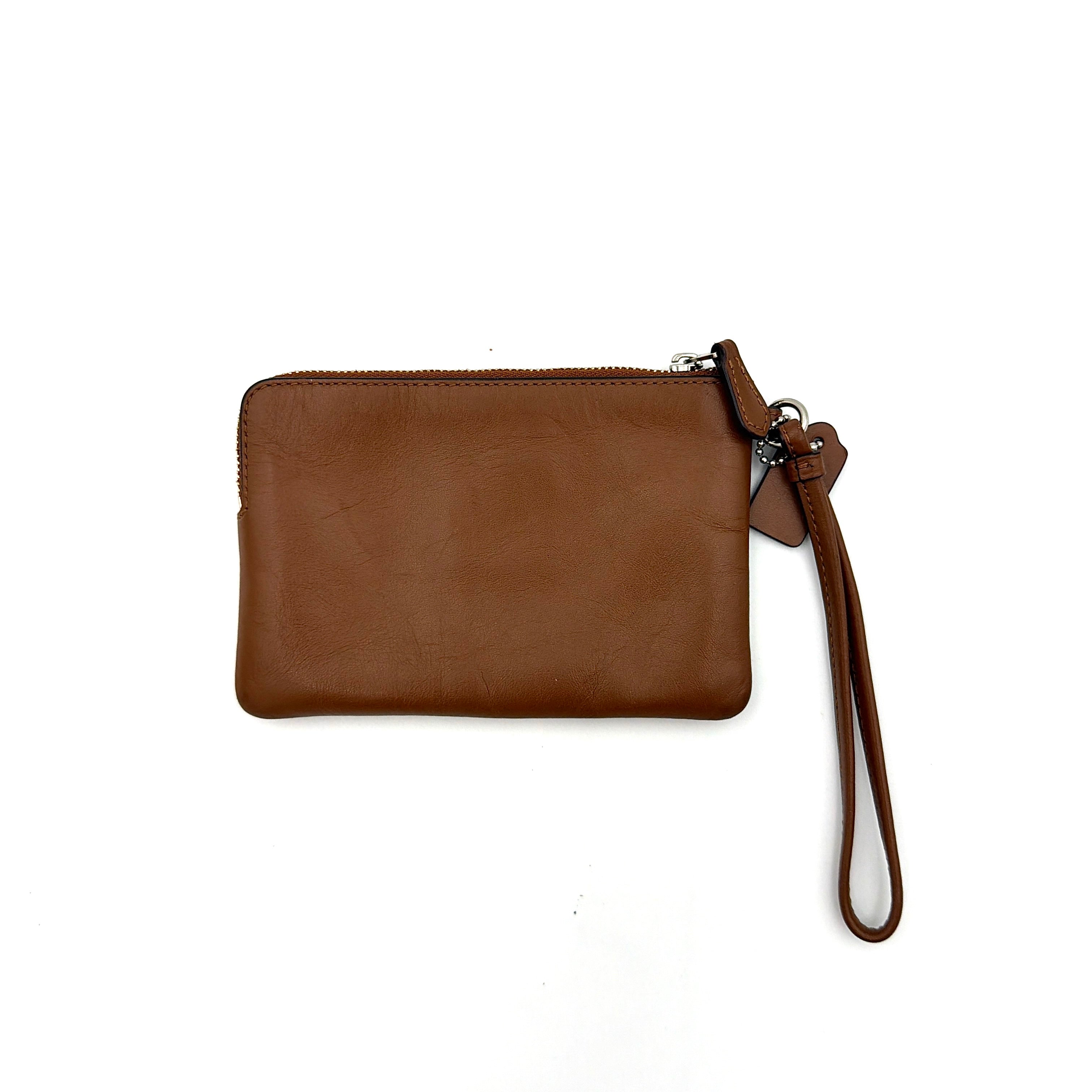 Coach Corner Zip Wristlet in smooth brown leather with silver logo and detachable wrist strap shown against a clean background.