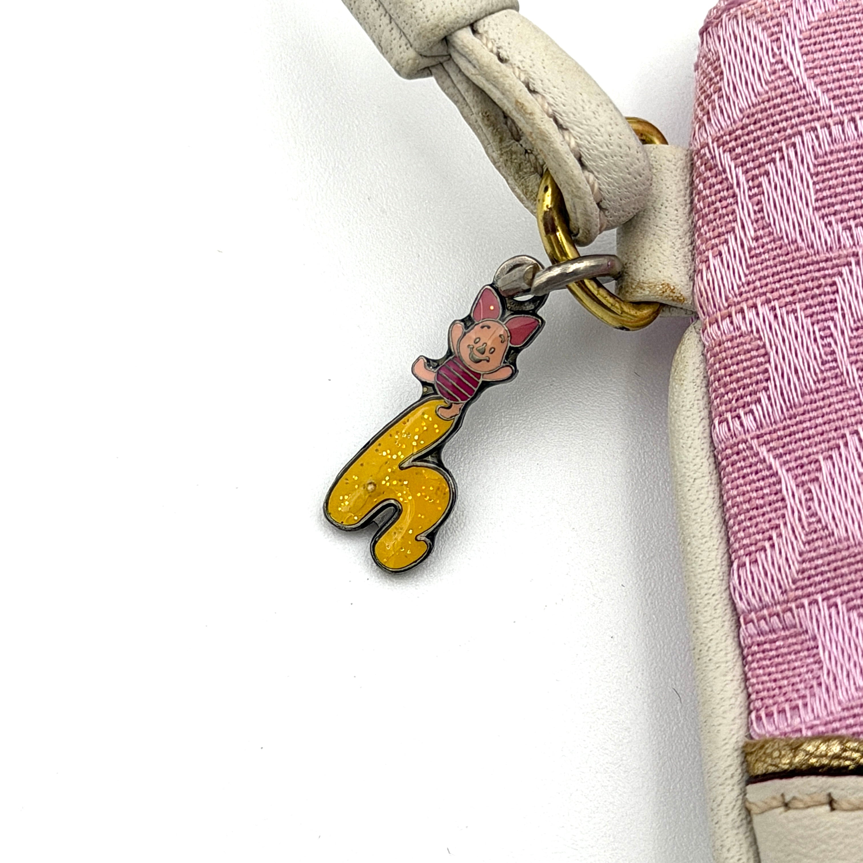 Coach Y2K Signature Canvas Wristlet in pink with white leather trim and a whimsical Piglet charm detail.